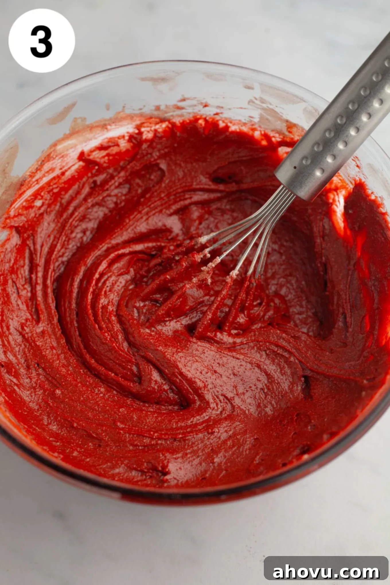 Red velvet brownie batter in a glass mixing bowl.