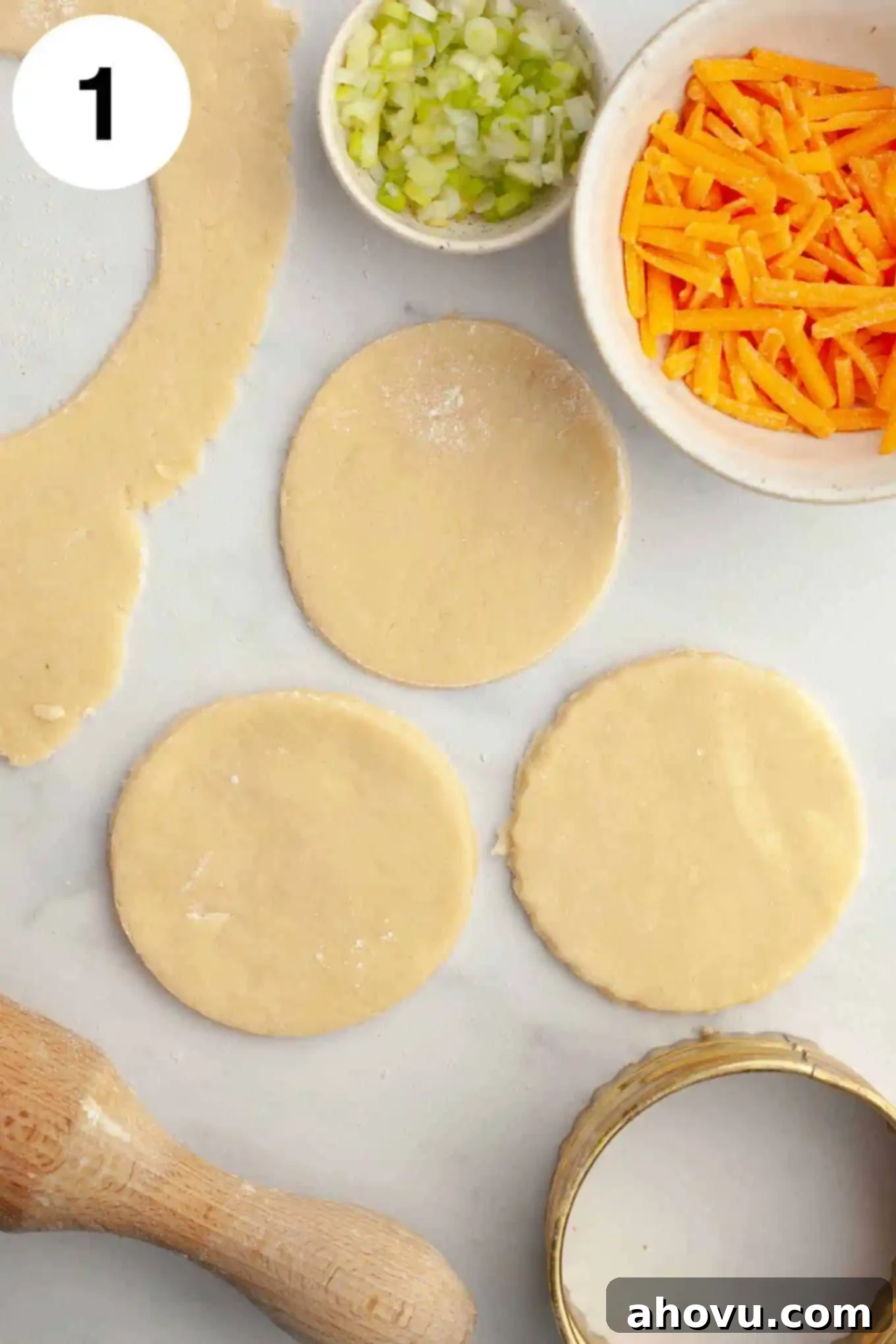 An overhead view of three mini pie crust circles with various quiche filling ingredients neatly portioned into small bowls, ready for assembly.