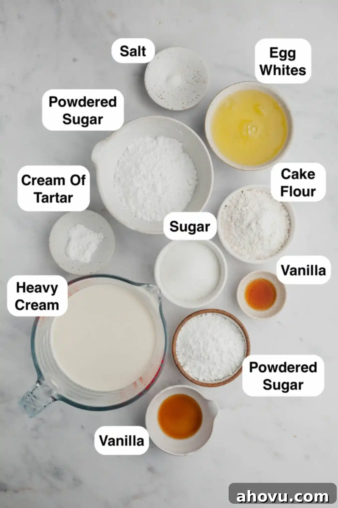 An overhead view of the essential ingredients laid out for preparing homemade angel food cake cupcakes, including flour, sugar, and eggs.