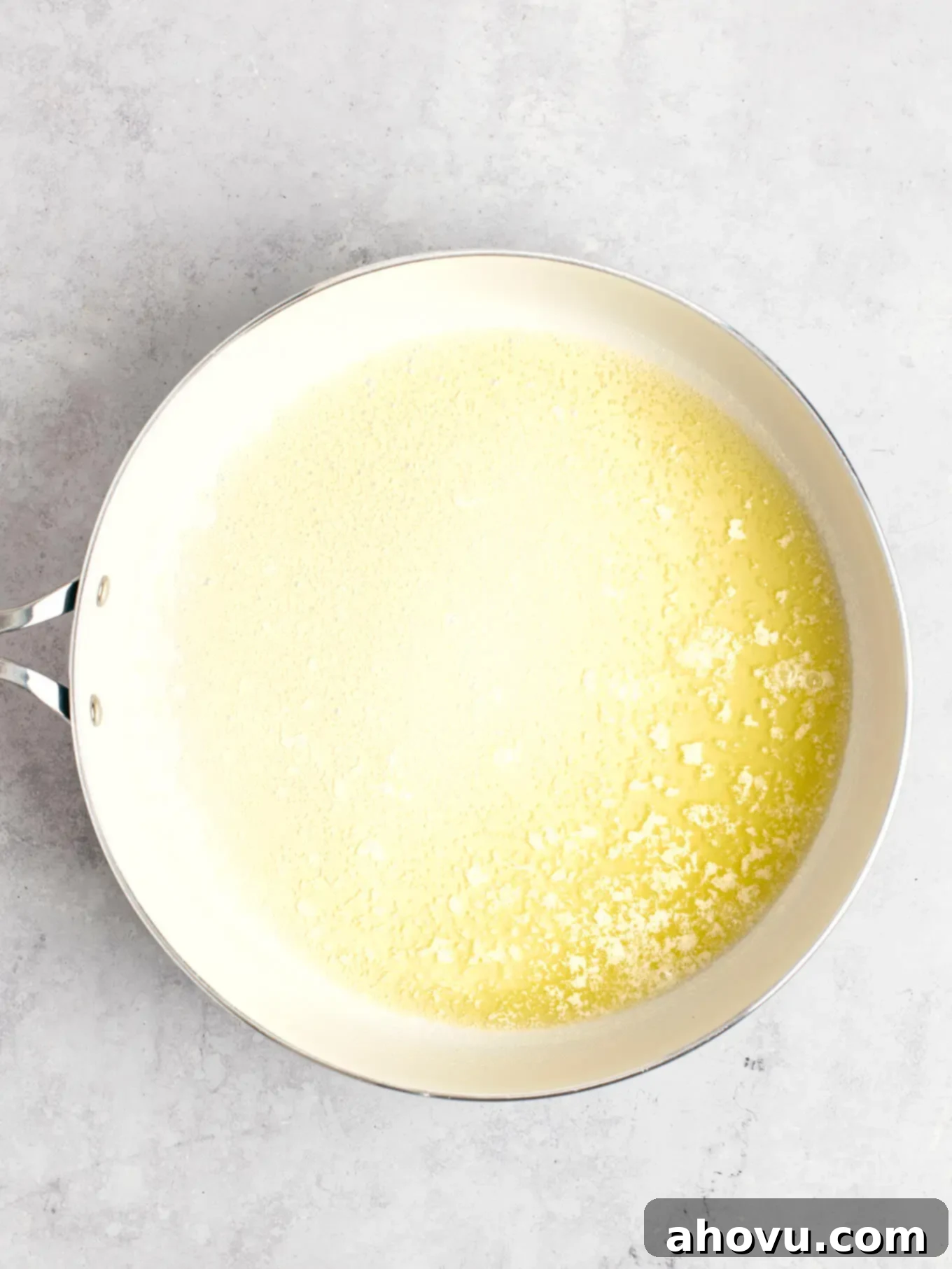 The Art of Brown Butter 5 Melted butter in a white skillet, showing the initial stage before foaming and browning begins.