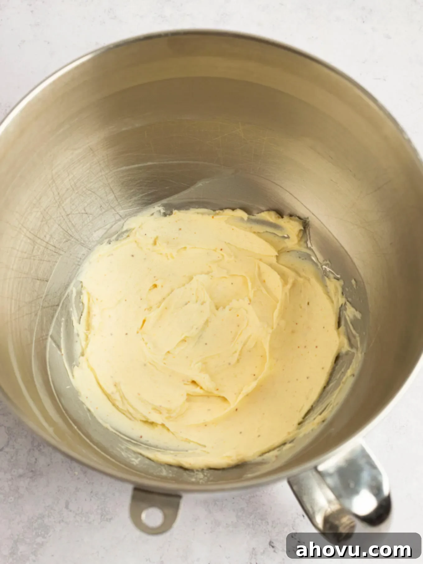 Regular softened butter and cooled browned butter mixed together in the bowl of a stand mixer, ready for powdered sugar.