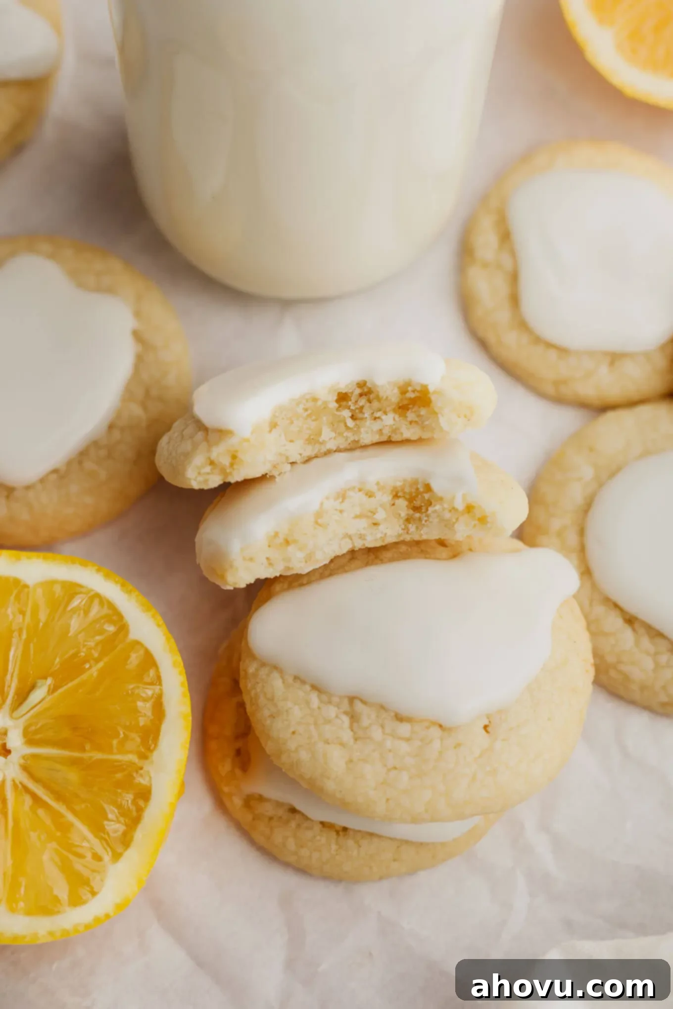An overhead view of several lemon meltaways stacked on their sides, revealing their perfectly soft, tender texture inside, with a delicate glaze on top.