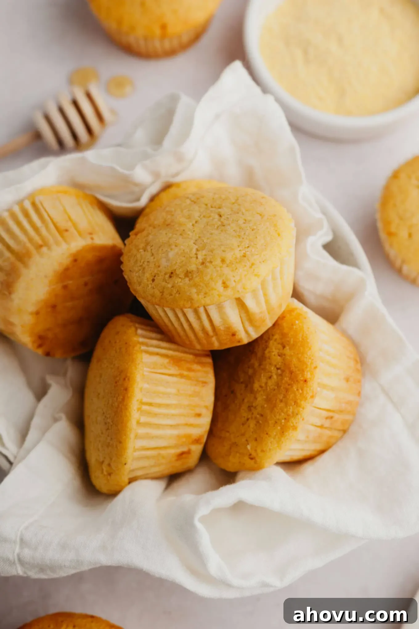 A pile of cornbread muffins in a towel-lined serving bowl. 