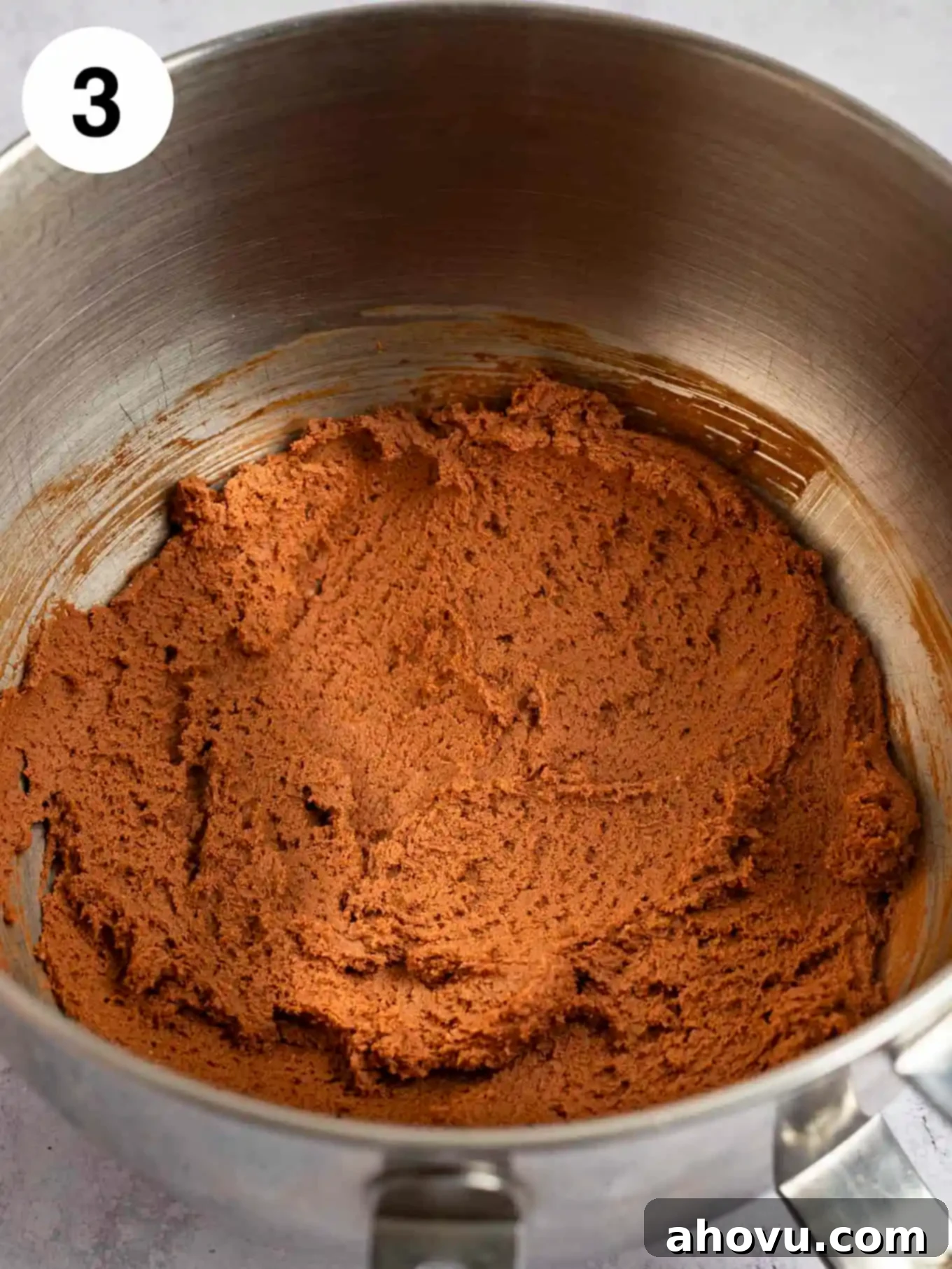 Rich chocolate cookie dough fully mixed together in the bowl of a stand mixer, showcasing its smooth and consistent texture.