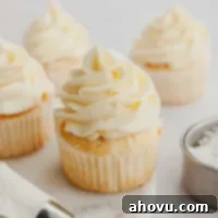 Several coconut cupcakes topped with coconut frosting.