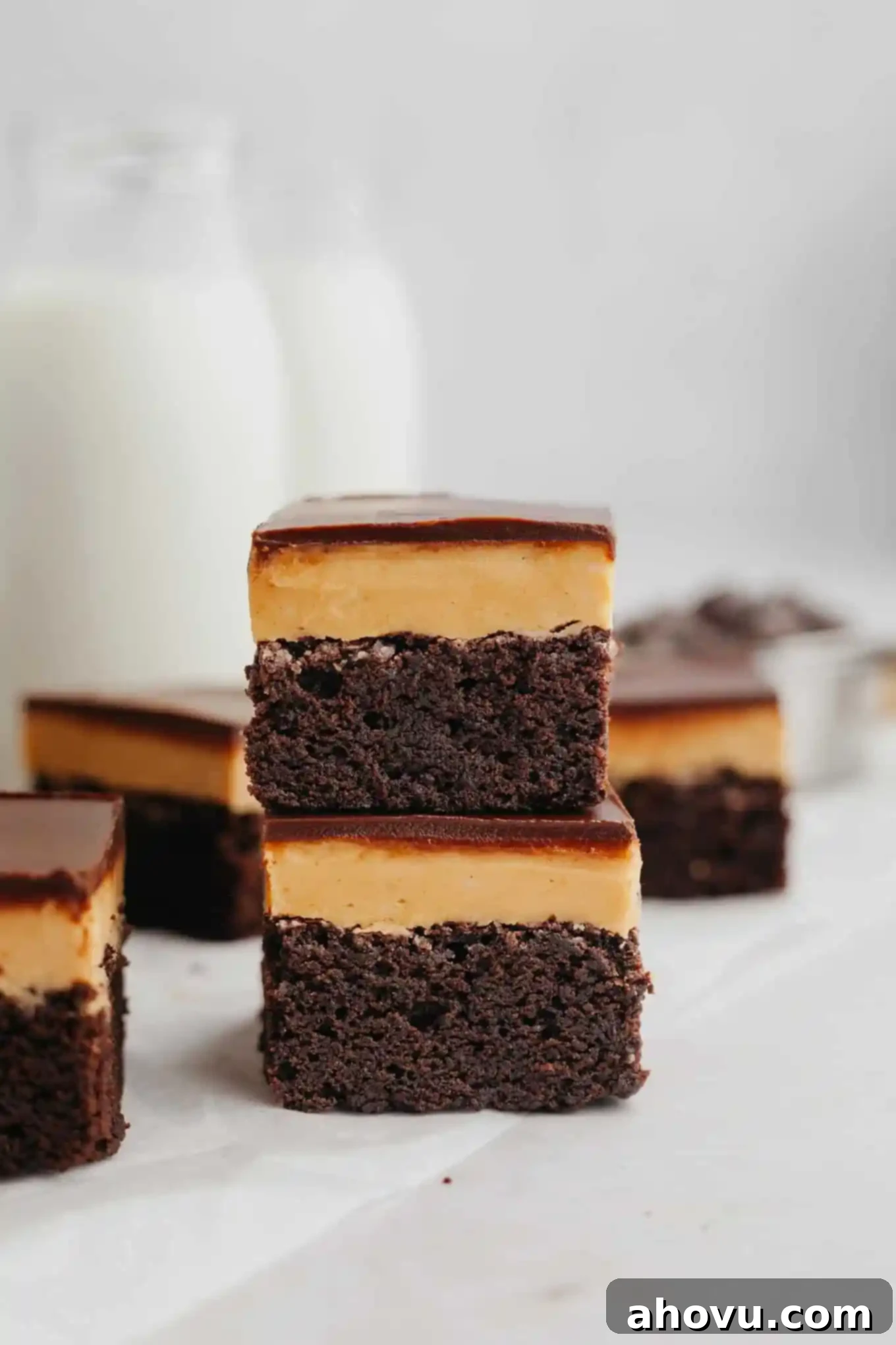 Buckeye Bliss Brownies 2 Two Buckeye brownies stacked on top of each other, showcasing their distinct layers of rich chocolate and creamy peanut butter fudge.