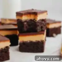 Buckeye Bliss Brownies 12 A stack of two buckeye brownies, the top brownie has a bite missing, showcasing its delicious layers.