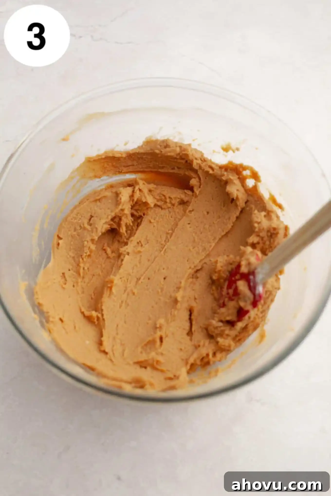 Buckeye Bliss Brownies 6 An overhead view of creamy peanut butter fudge in a clear glass mixing bowl, its smooth texture ready for layering.
