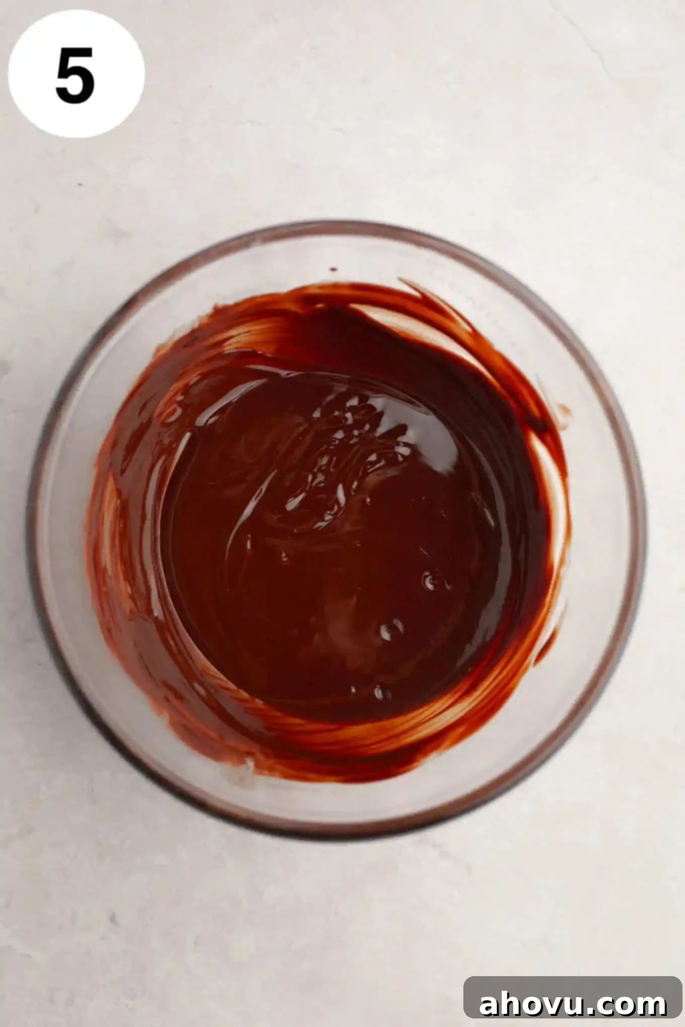 Buckeye Bliss Brownies 8 An overhead view of perfectly melted, glossy chocolate in a clear glass bowl, ready for drizzling or spreading.