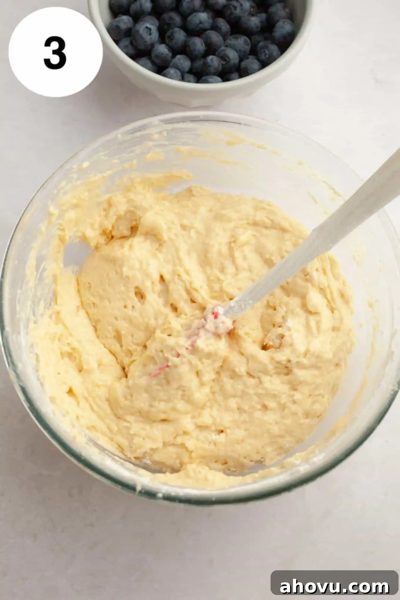 An overhead view of quick bread batter in a glass mixing bowl. 