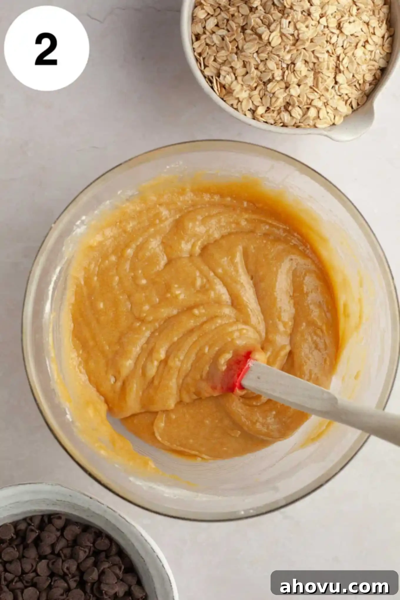 An overhead view of the wet and dry ingredients mixed together, forming the oatmeal cookie bar dough.