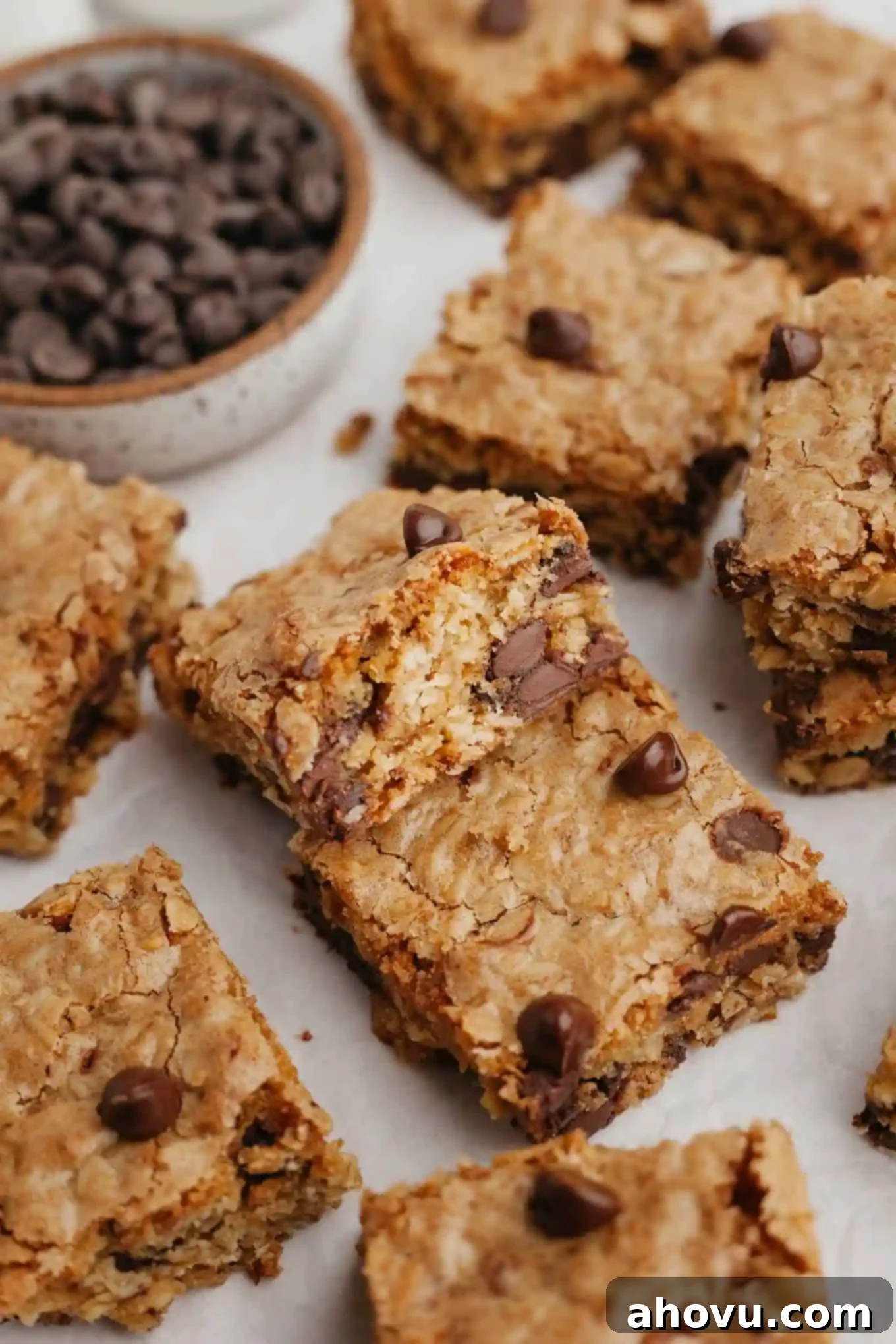 Oatmeal bar cookies arranged haphazardly on a white surface, showing their golden brown tops and delicious texture.