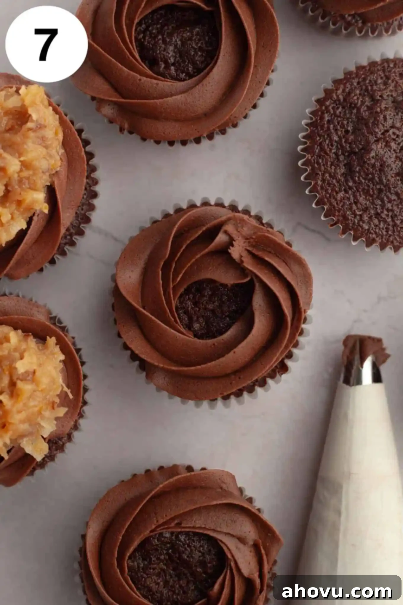 Decadent German Chocolate Cupcakes 11 An overhead shot of chocolate cupcakes with a neat, decorative border of chocolate frosting piped around the edge of each, ready for the next frosting layer.