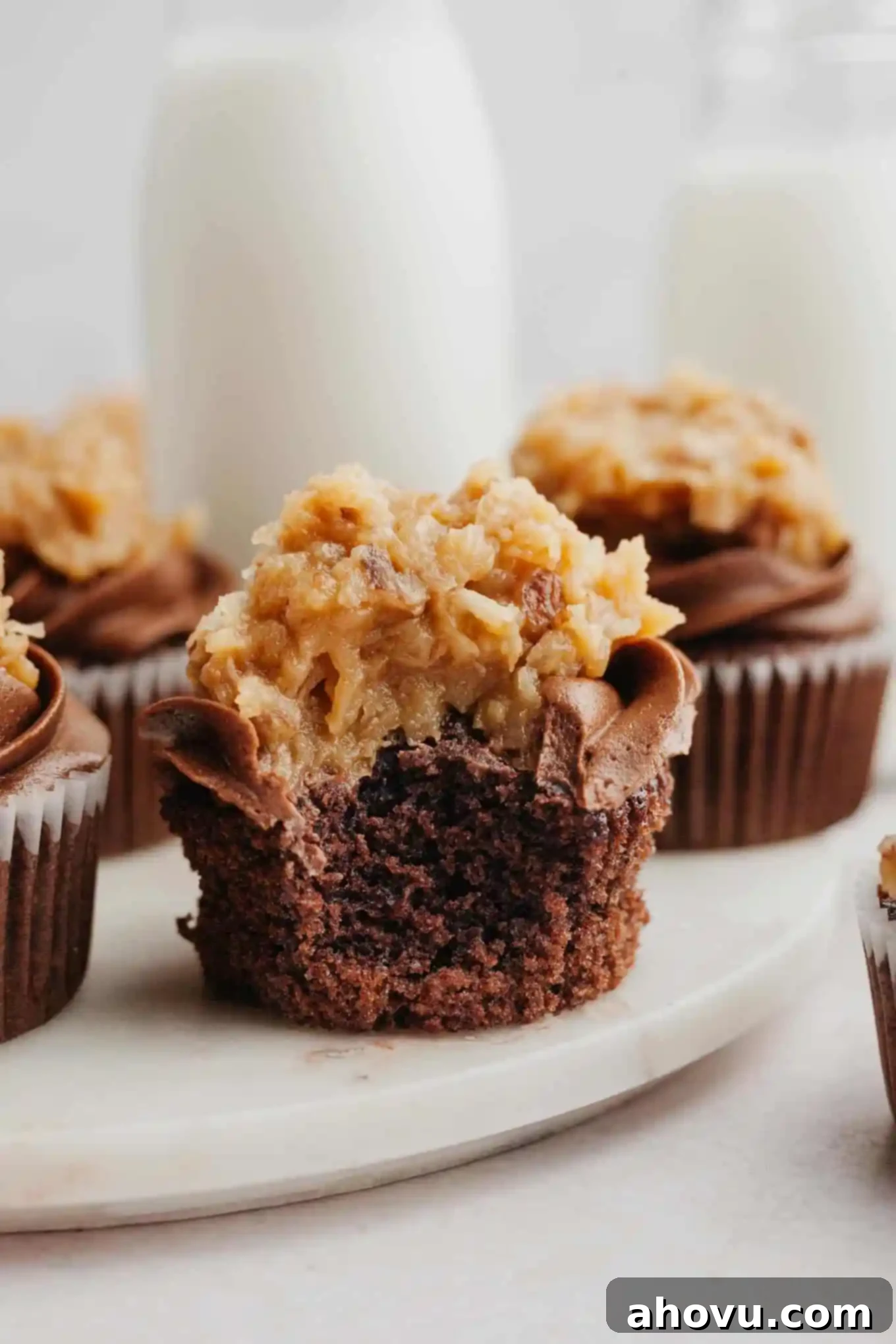 Decadent German Chocolate Cupcakes 14 Frosted German chocolate cupcakes arranged perfectly on a marble serving platter, highlighting the delicious texture of the coconut pecan frosting and the rich chocolate base.