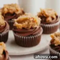 Several German Chocolate cupcakes on a marble serving plate.