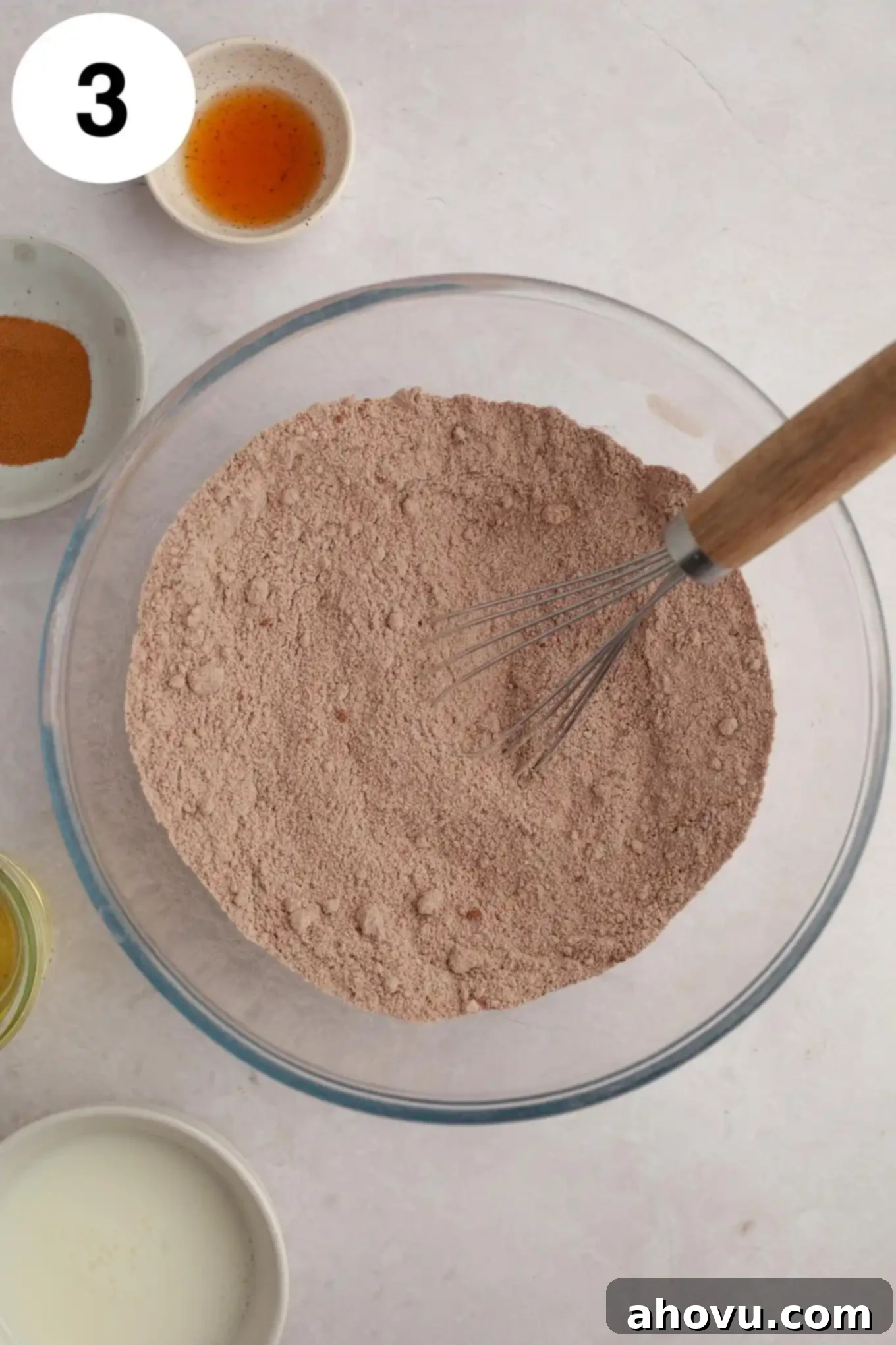 Decadent German Chocolate Cupcakes 7 An overhead view of a glass mixing bowl with dry ingredients (flour, cocoa powder, leavening agents, salt) neatly sifted and ready for whisking.