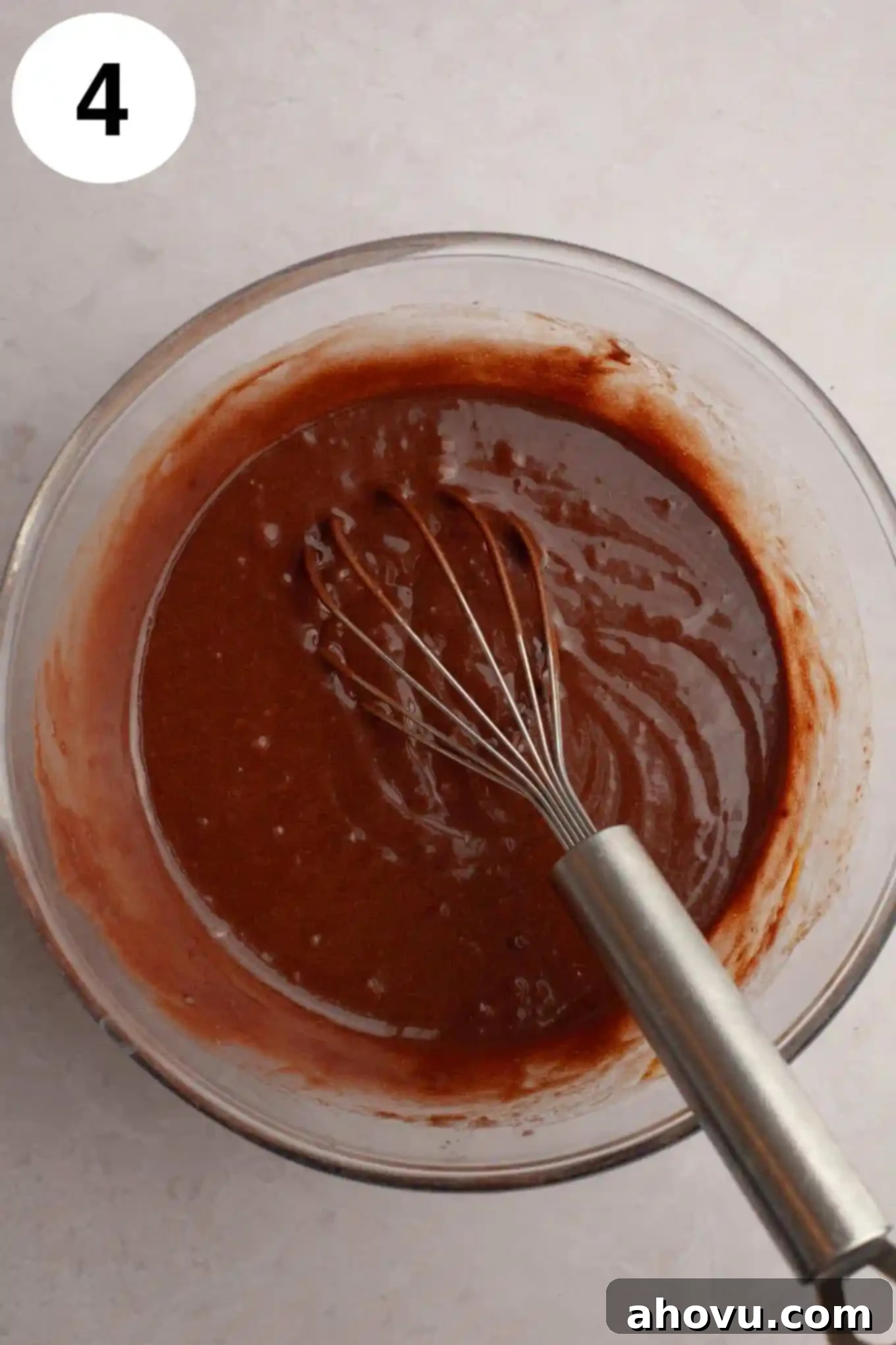 Decadent German Chocolate Cupcakes 8 An overhead view showing a whisk combining wet ingredients (oil, buttermilk, egg, vanilla extract) in a separate glass mixing bowl, creating a smooth mixture.