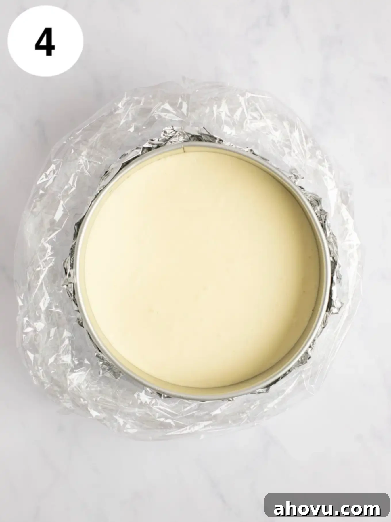 Your Guide to a Perfect Cheesecake Water Bath 8 A cheesecake in a springform pan that's wrapped in foil and an oven bag.