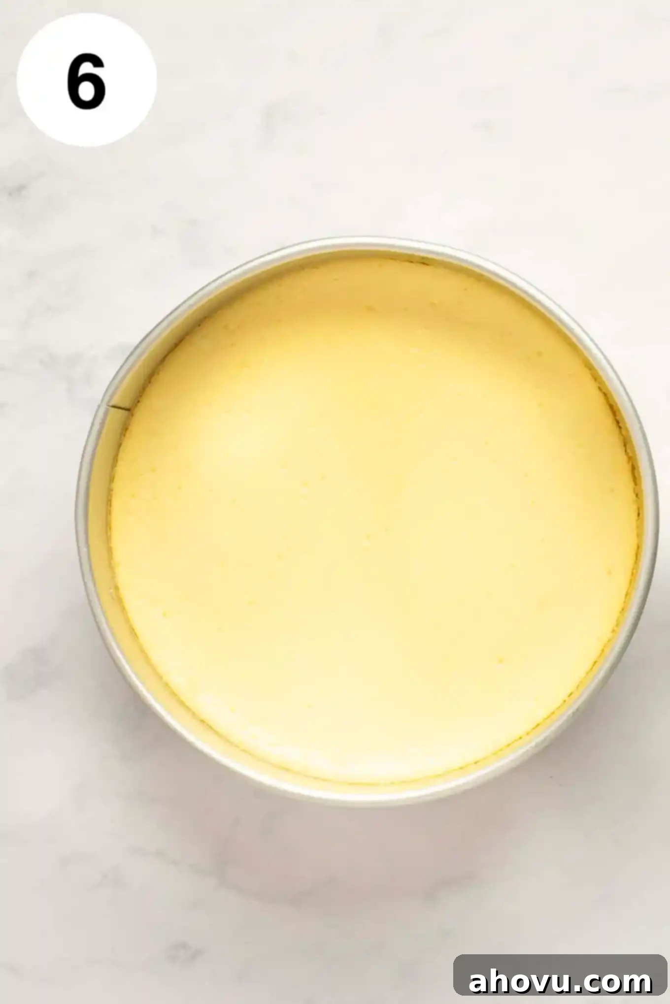 Your Guide to a Perfect Cheesecake Water Bath 10 A baked cheesecake inside of the springform pan on a marble surface.