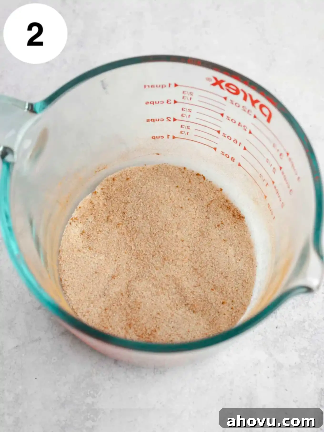Sugar, cinnamon, and nutmeg whisked together in a large measuring cup.