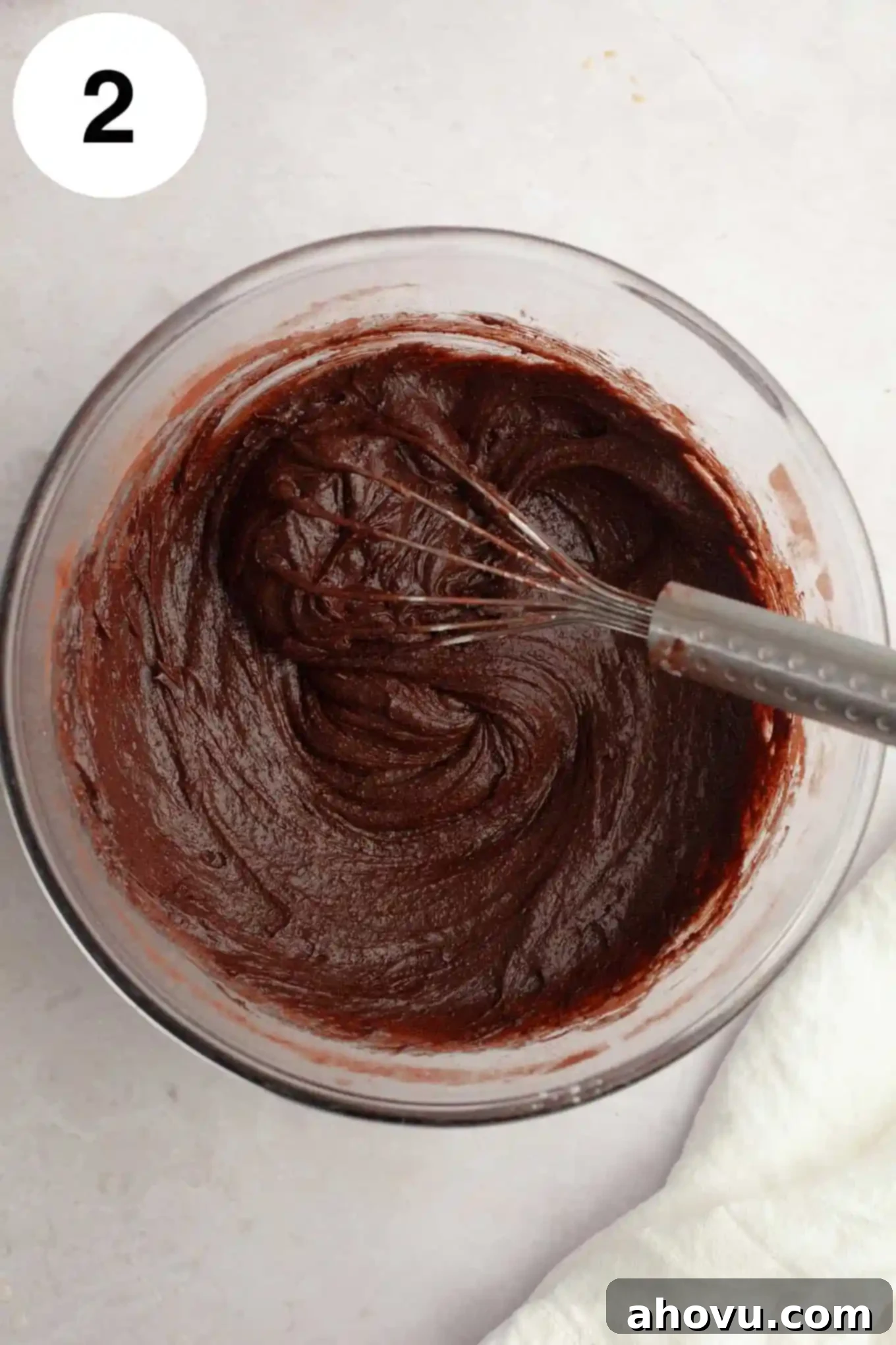 Gems of the Current 5 An overhead view of brownie batter in a glass mixing bowl, with a whisk.