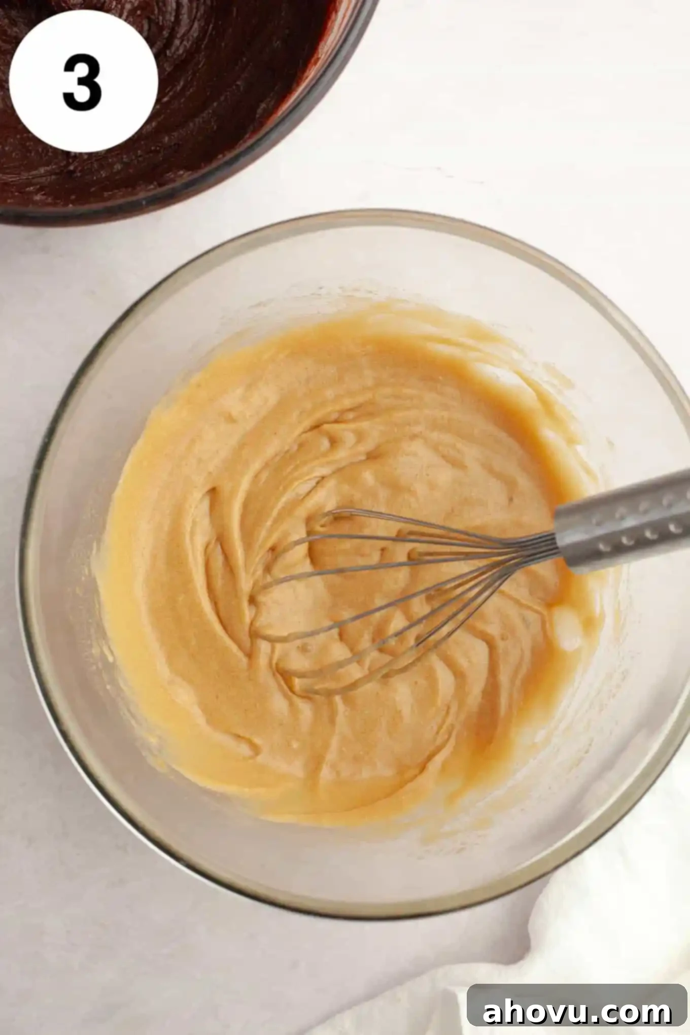 Gems of the Current 6 An overhead view of melted butter, eggs, and sugar in a glass mixing bowl, with a whisk.