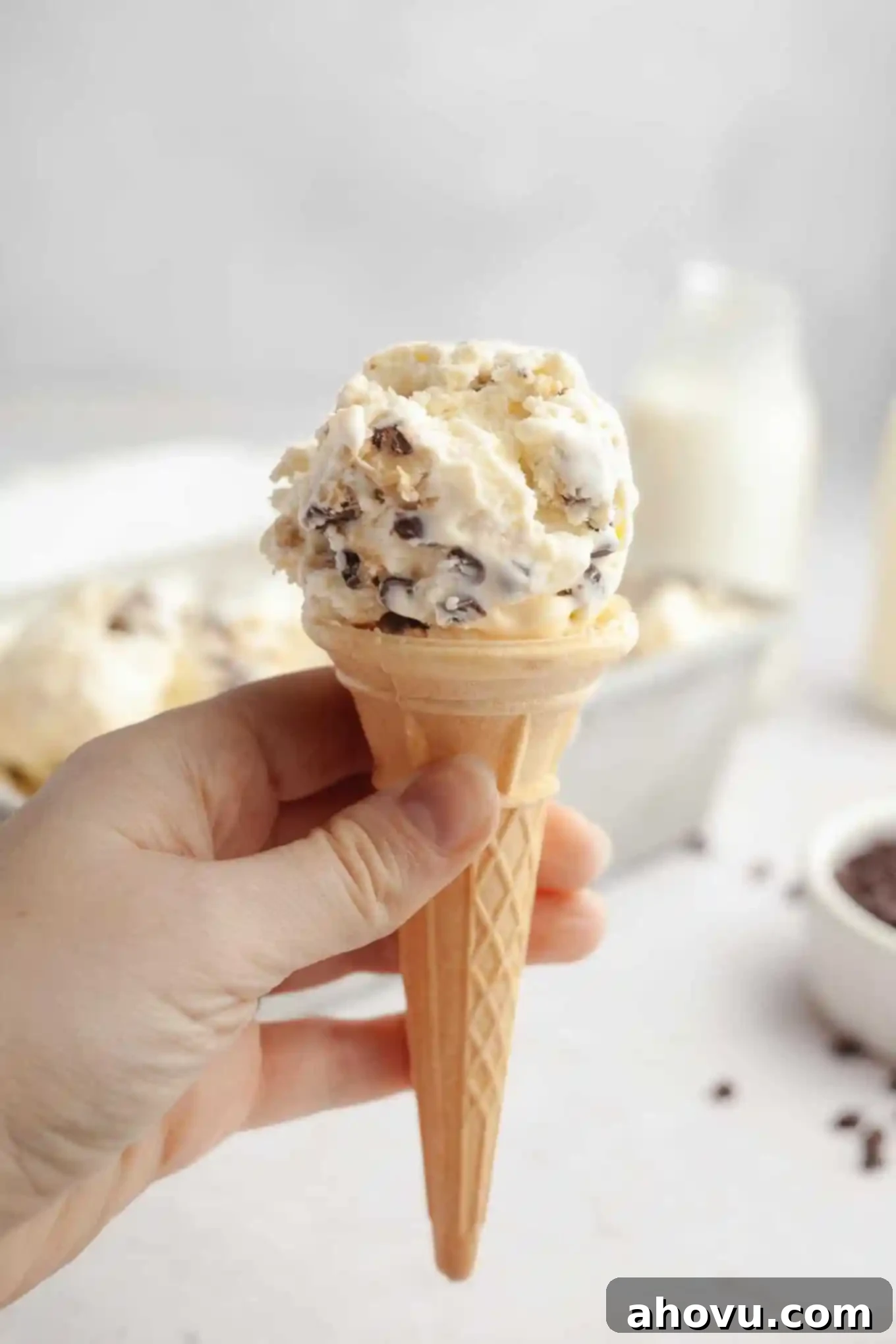 An ice cream cone being held aloft. 