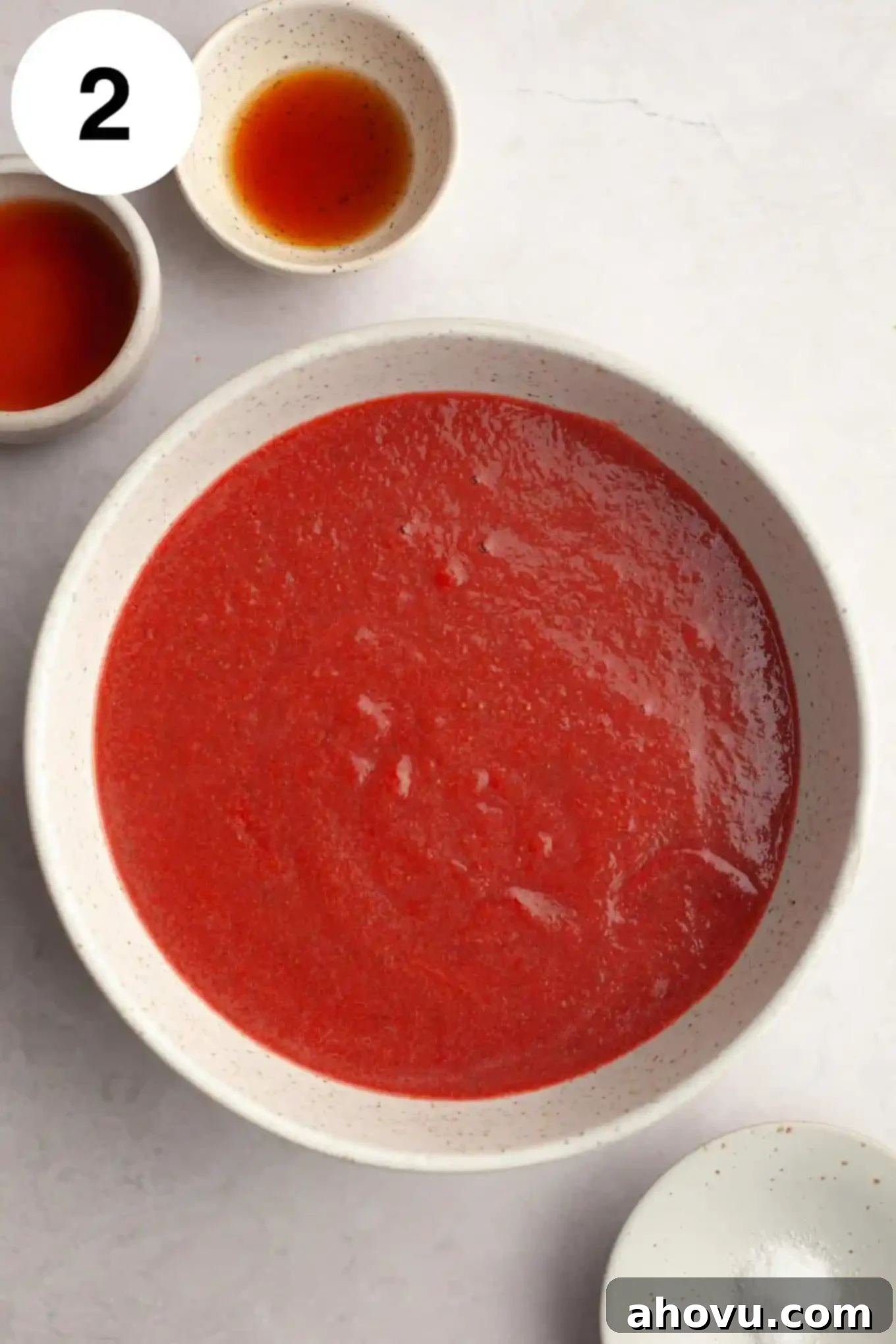 An overhead view of the concentrated, reduced strawberry puree in a clean bowl, showing its deeper color and thicker consistency after cooking.
