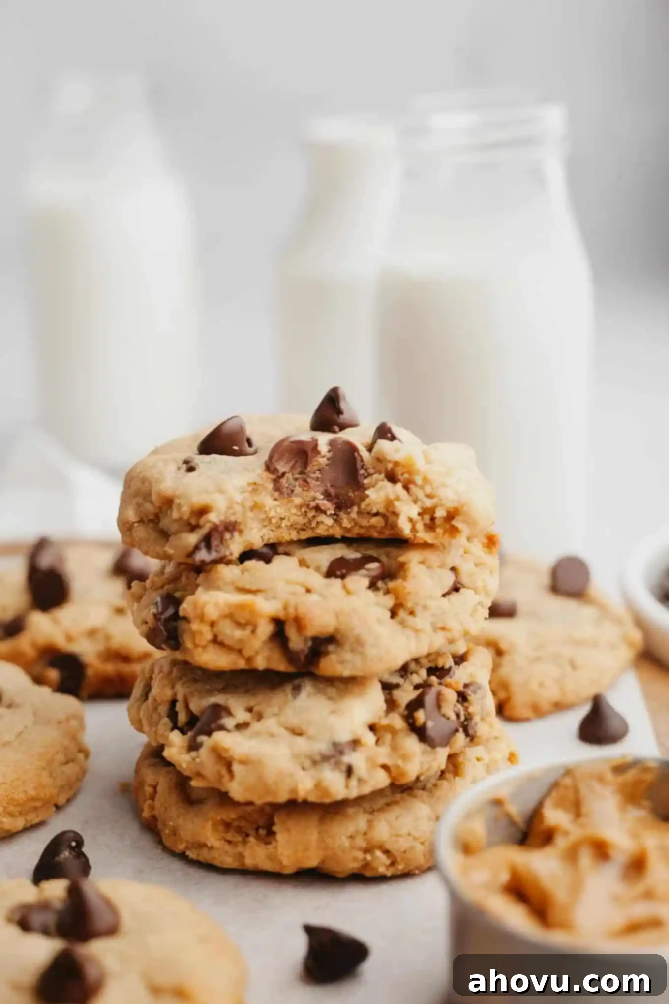 Irresistible Peanut Butter Chocolate Chip Cookies 2 A stack of four peanut butter chocolate chip cookies; the top cookie has a bite missing.