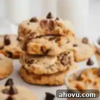 Irresistible Peanut Butter Chocolate Chip Cookies 12 A stack of peanut butter chocolate chip cookies. The top cookie has a bite missing to show the texture.
