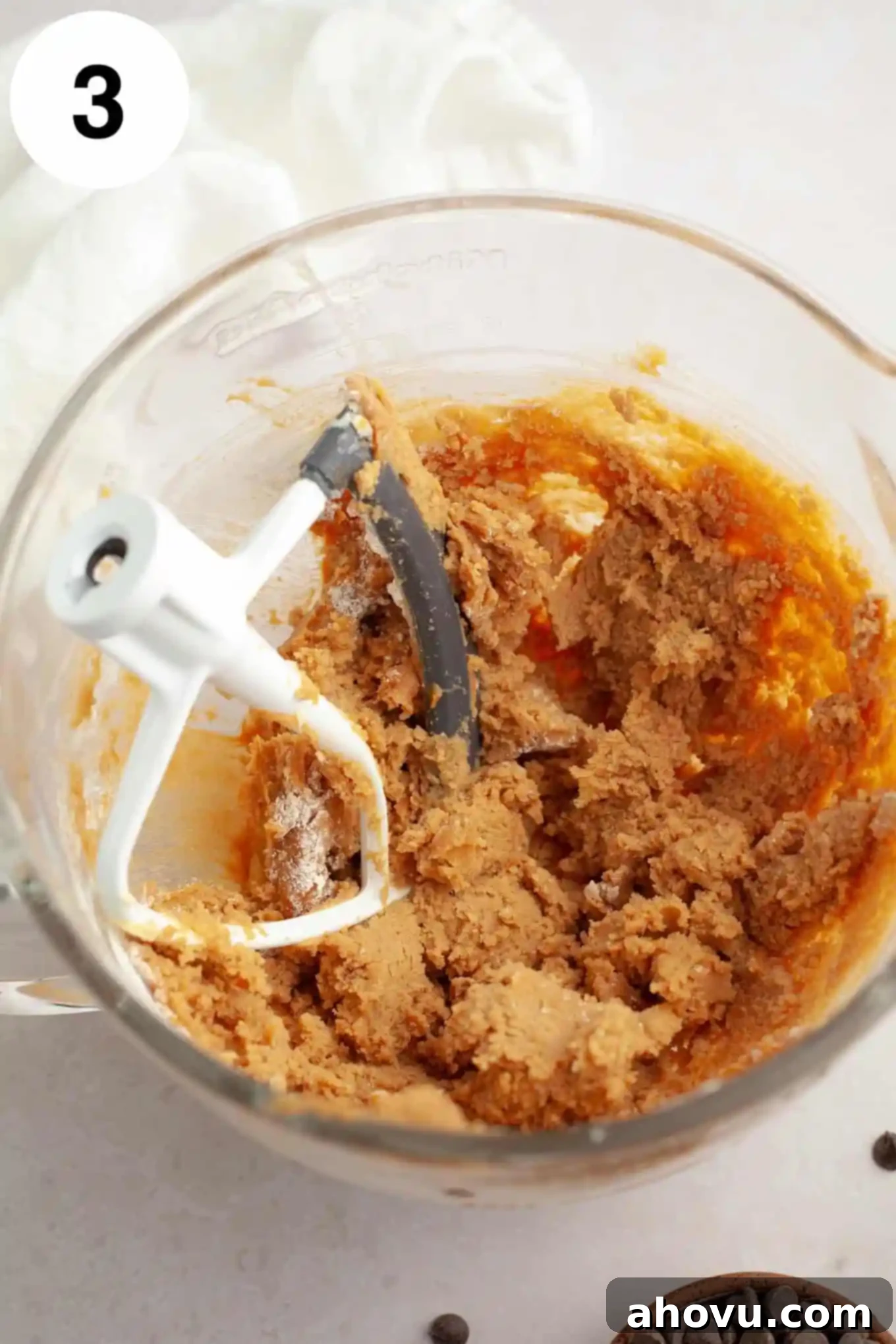 Irresistible Peanut Butter Chocolate Chip Cookies 6 An overhead view of peanut butter cookie dough in a glass mixing bowl.