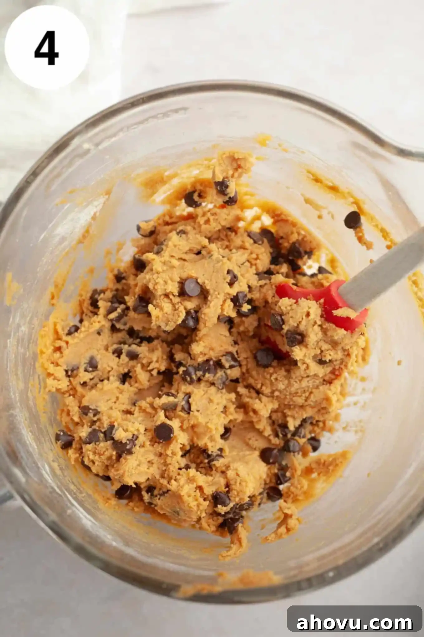 Irresistible Peanut Butter Chocolate Chip Cookies 7 An overhead view of peanut butter chocolate chip cookie dough in a glass mixing bowl.