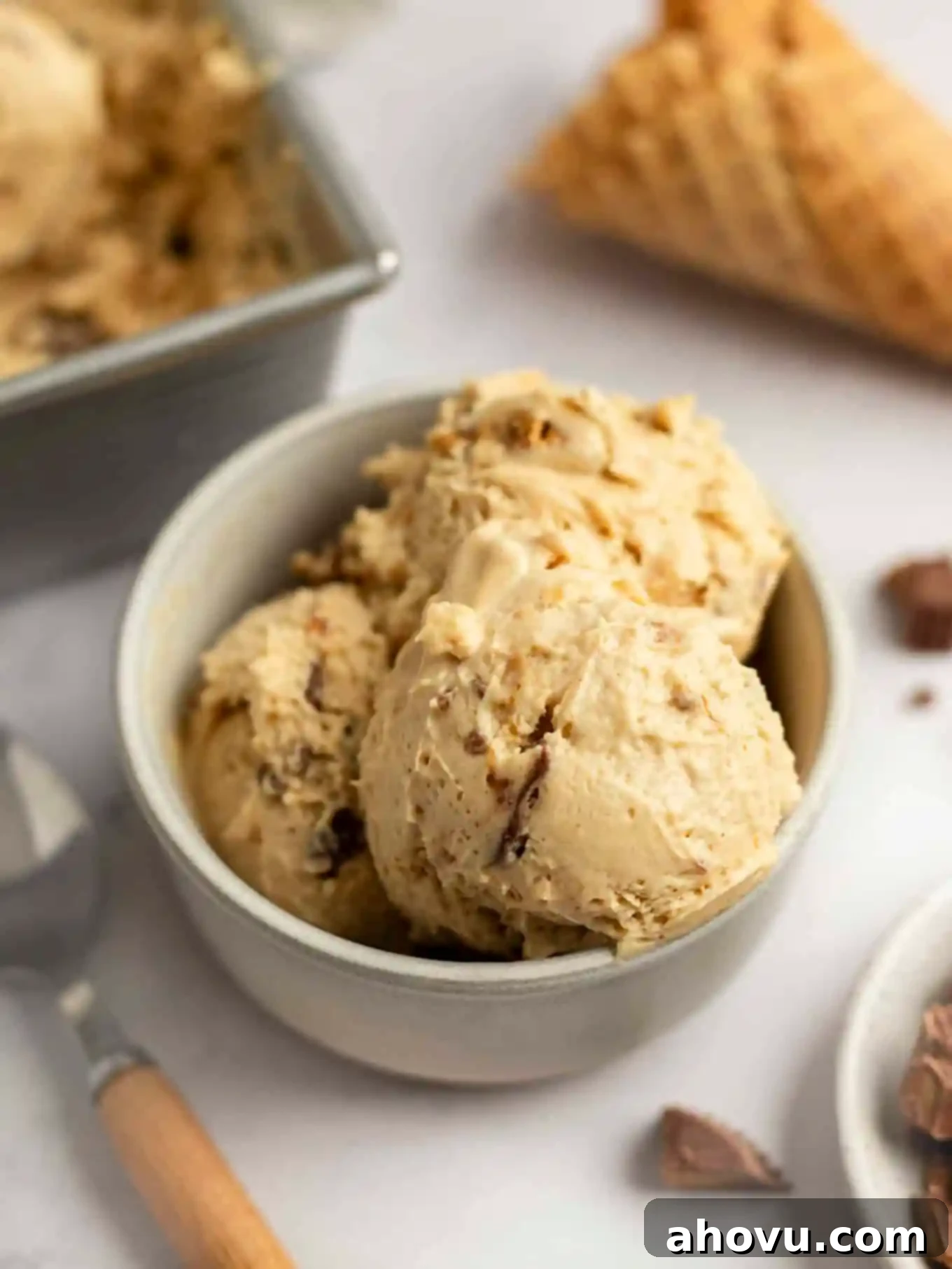 Velvet Peanut Butter Freeze 2 Three scoops of peanut butter ice cream in a small bowl, garnished with chopped peanut butter cups.