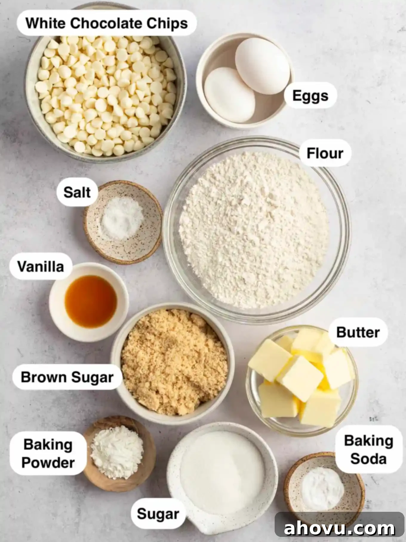 An overhead view showcasing all the essential ingredients laid out for making delicious white chocolate chip cookies, including flour, sugars, butter, eggs, and plenty of white chocolate chips.
