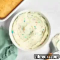 Joyful Confetti Frosting 12 A white bowl filled with rainbow chip frosting.