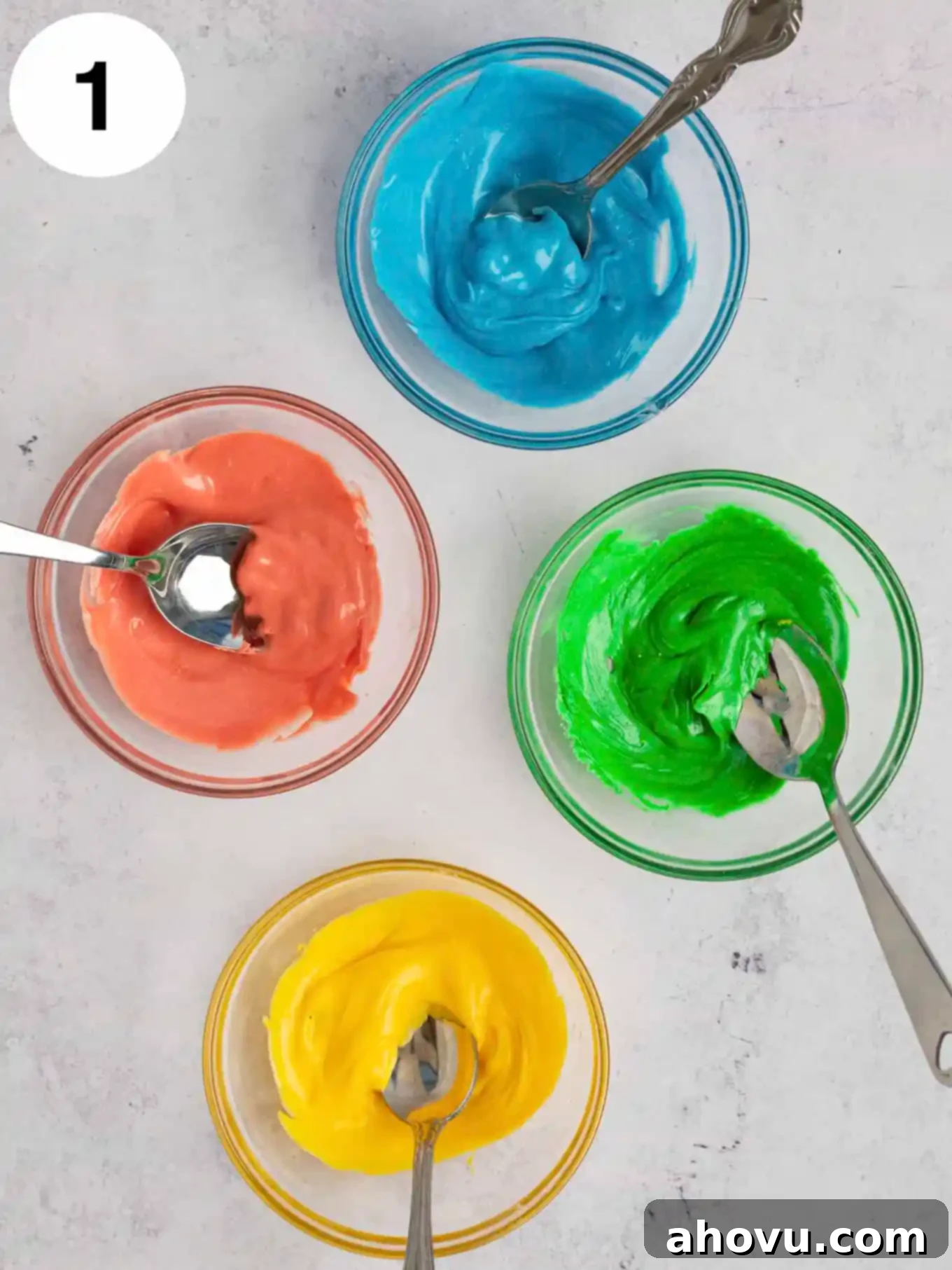 Joyful Confetti Frosting 4 An overhead view of four bowls of colored melted white chocolate.