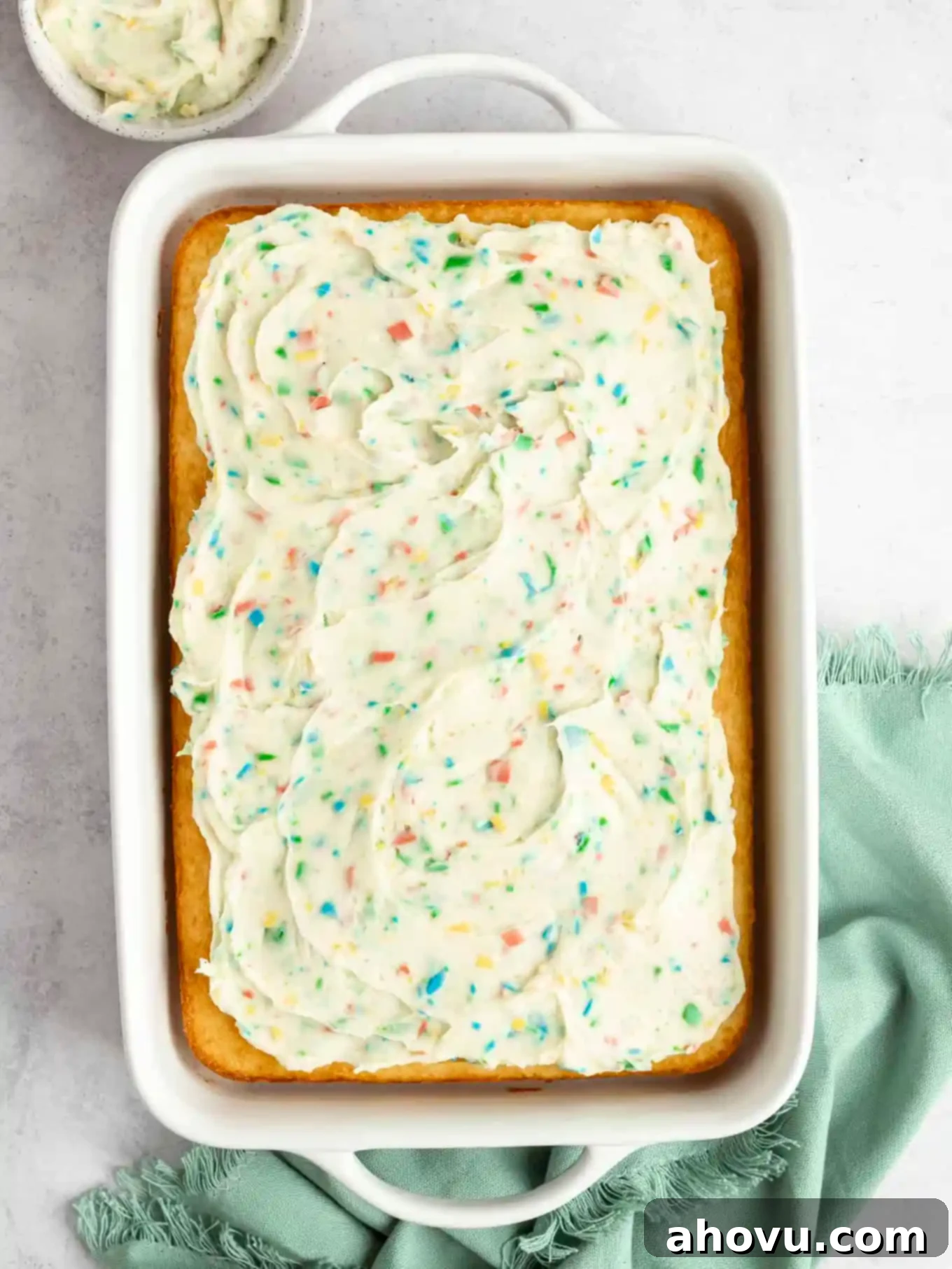 Joyful Confetti Frosting 10 An overhead view of a yellow cake topped with rainbow chip frosting.