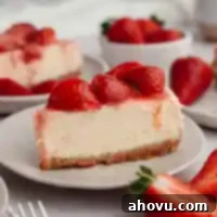 A slice of strawberry cheesecake on a white plate.