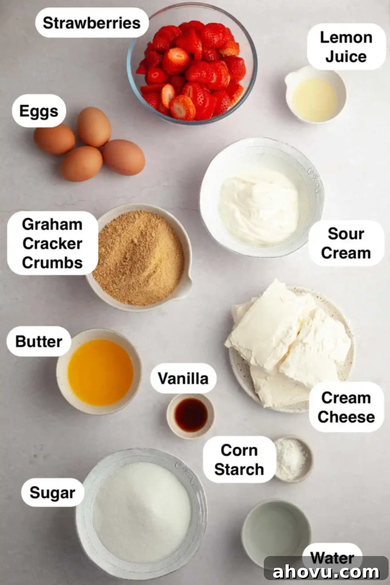 An overhead view displaying all the fresh and essential ingredients meticulously laid out for preparing a delicious strawberry cheesecake.