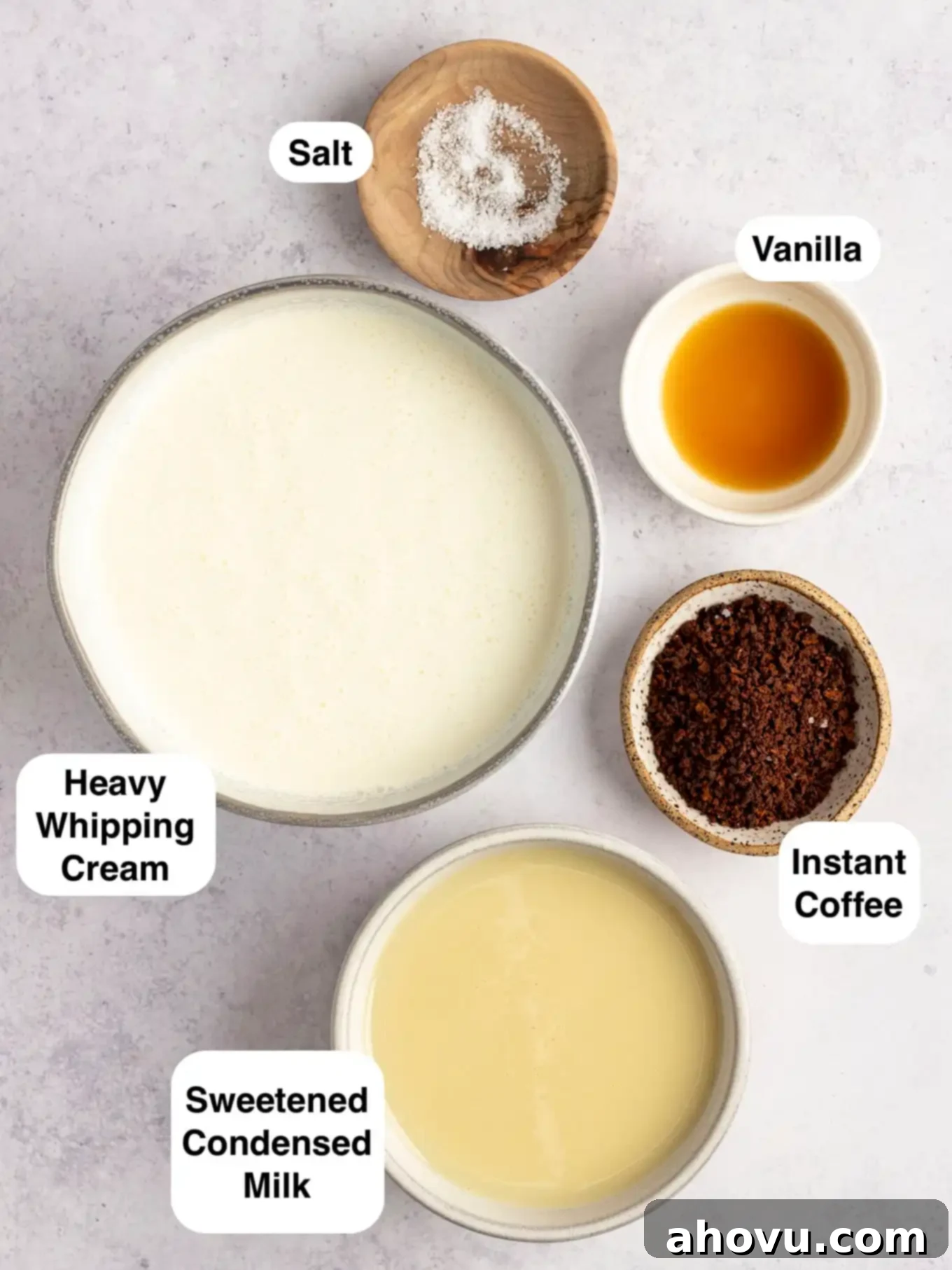 An overhead view showcasing all the essential ingredients laid out for making no-churn coffee ice cream, including heavy cream, sweetened condensed milk, instant coffee, vanilla extract, and salt.