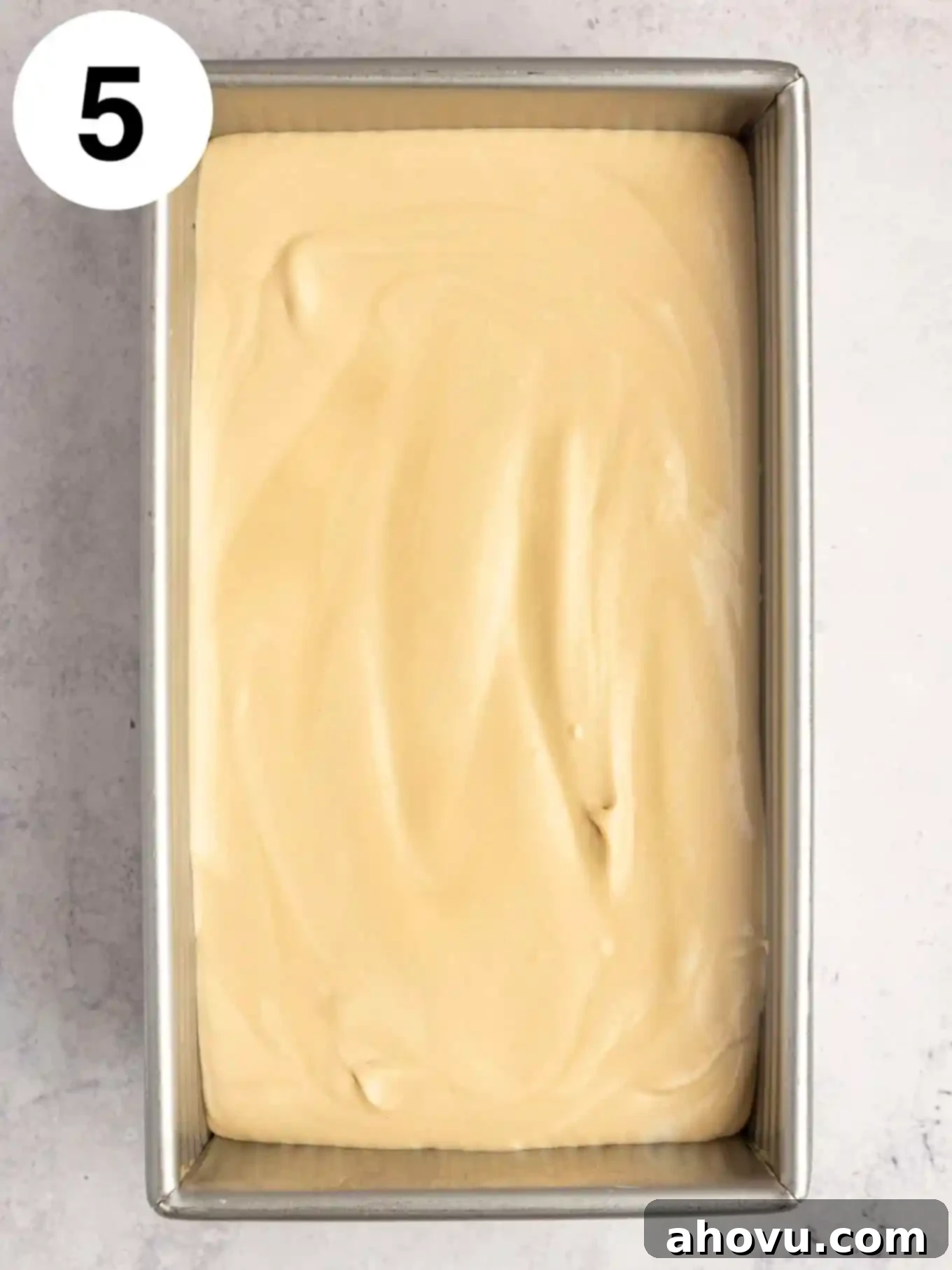 Coffee flavored ice cream mixture freshly scooped into a 9x5 inch loaf pan, ready for freezing.