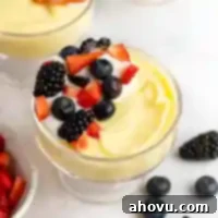 A bowl of vanilla pudding topped with fresh berries.