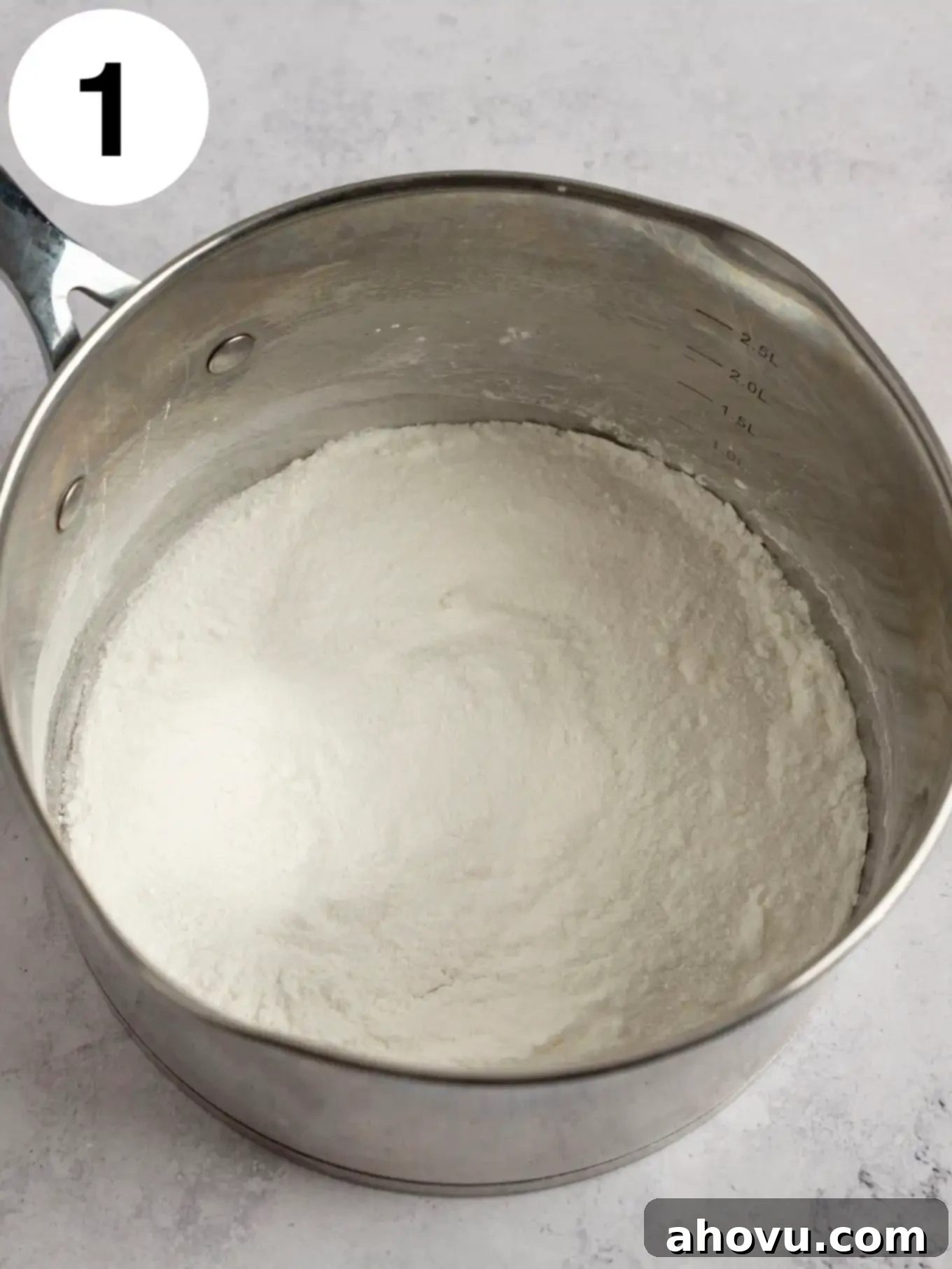 Creamy Vanilla Dream 4 An overhead view of cornstarch and granulated sugar being whisked together in a saucepan, showing the initial dry ingredient preparation step for homemade vanilla pudding.