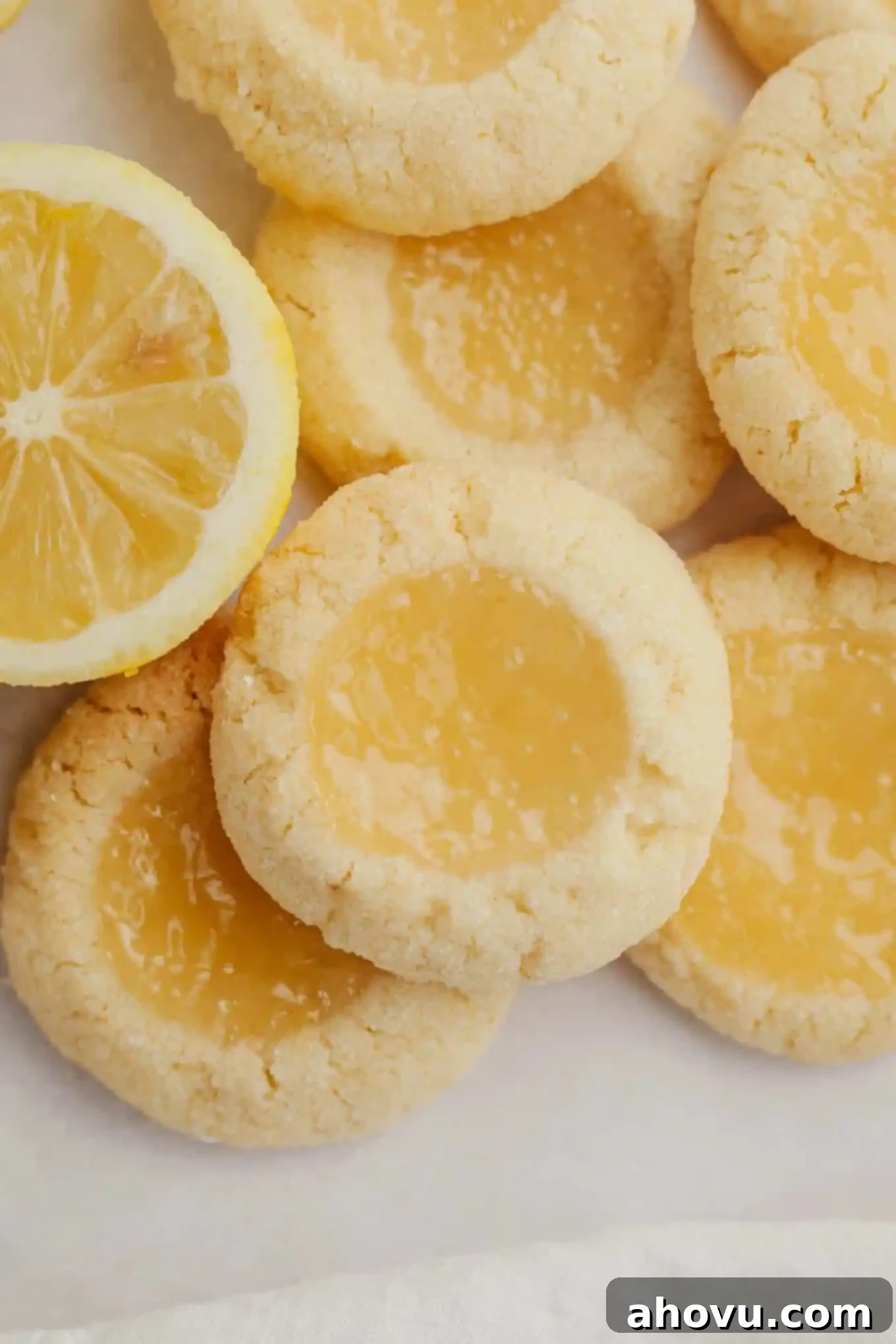A close-up, inviting overhead view of baked lemon curd filled lemon cookies, showcasing their golden edges and creamy, set filling.