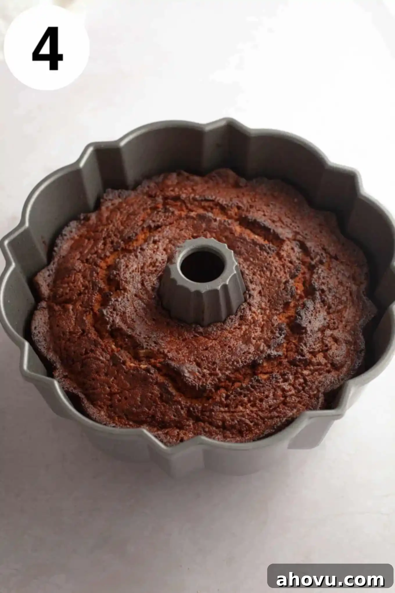 An overhead view of a freshly baked apple cider donut cake, still warm and golden in its bundt pan.