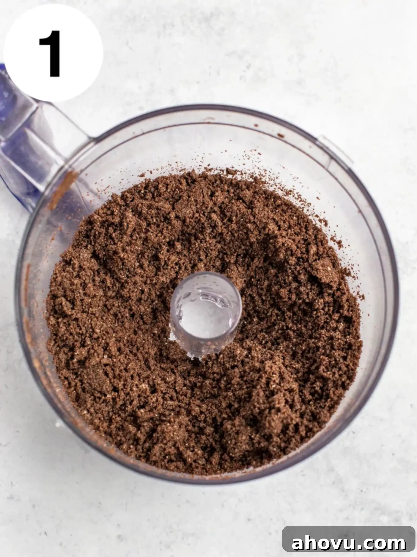 An overhead view of Oreo crumbs in the bowl of a food processor. 