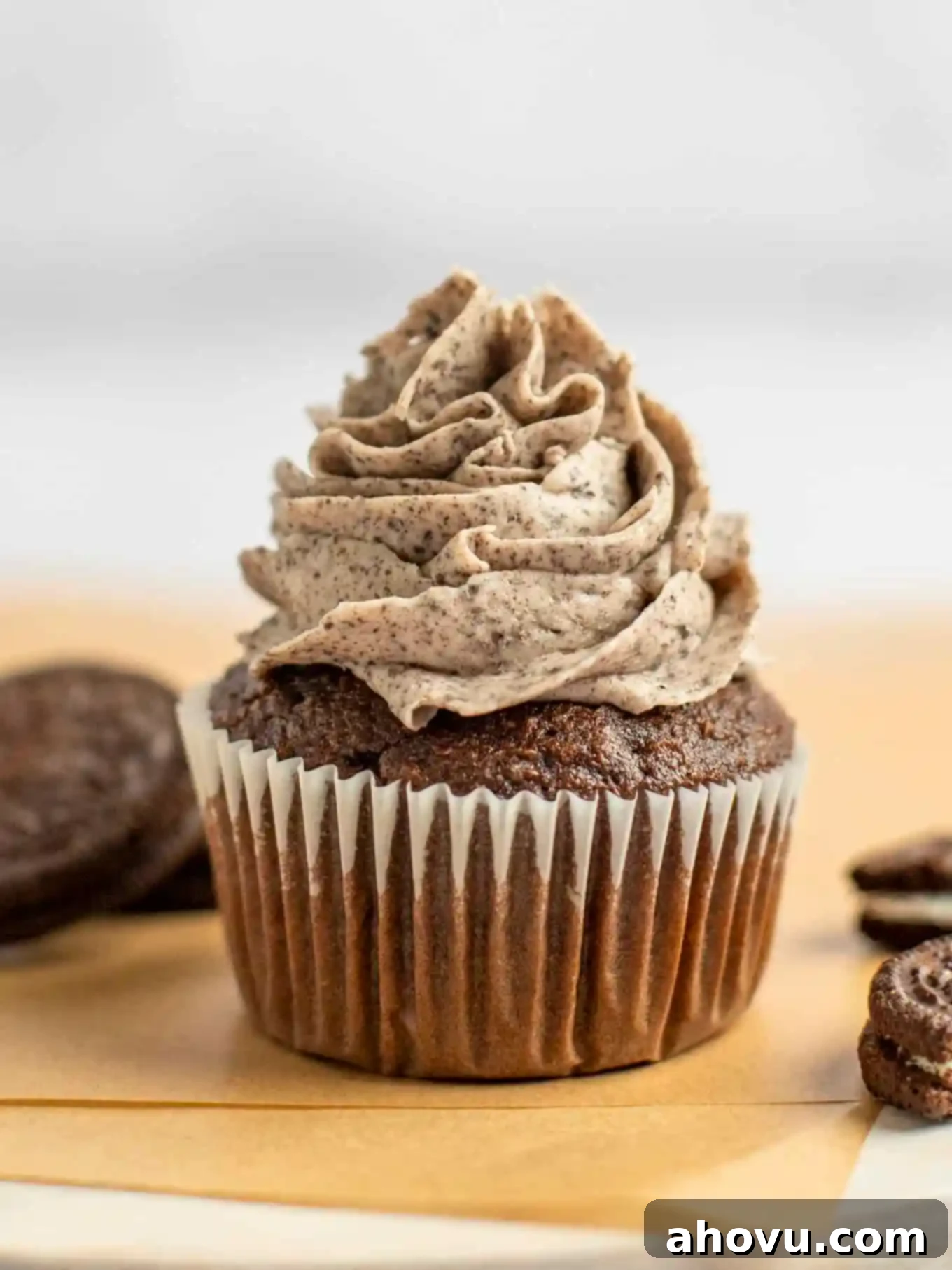 A side view of a chocolate cupcake piped with Oreo frosting. 