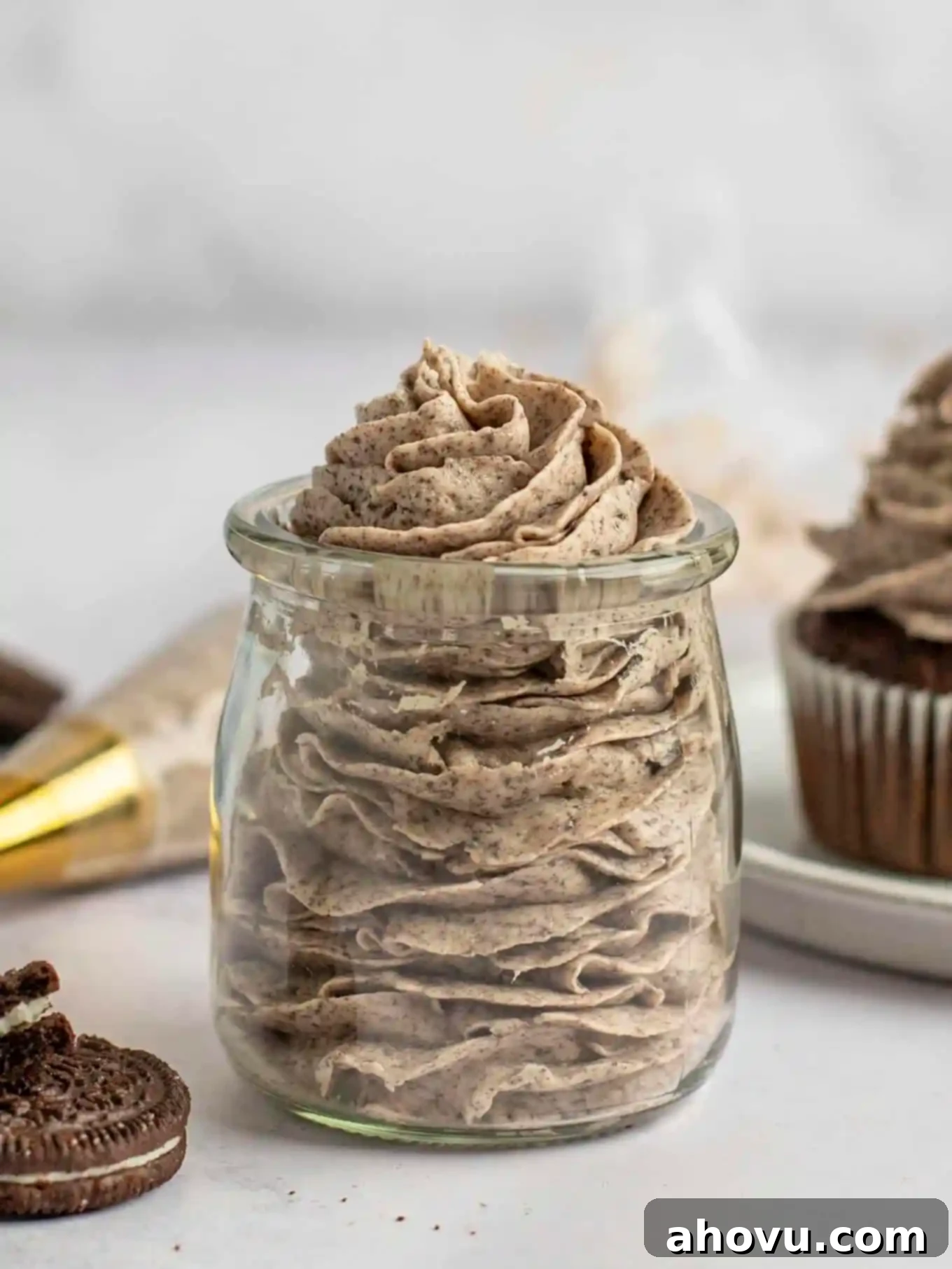 A side view of piped Oreo buttercream in a glass jar. 