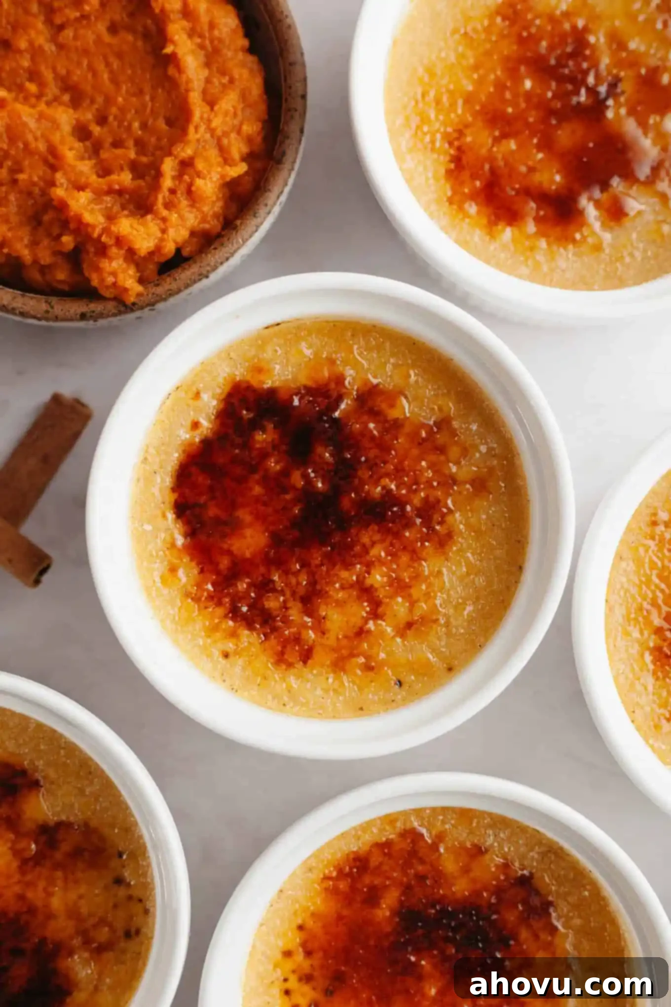 An overhead view of pumpkin crème brûlée in individual ramekins, ready to be served. 