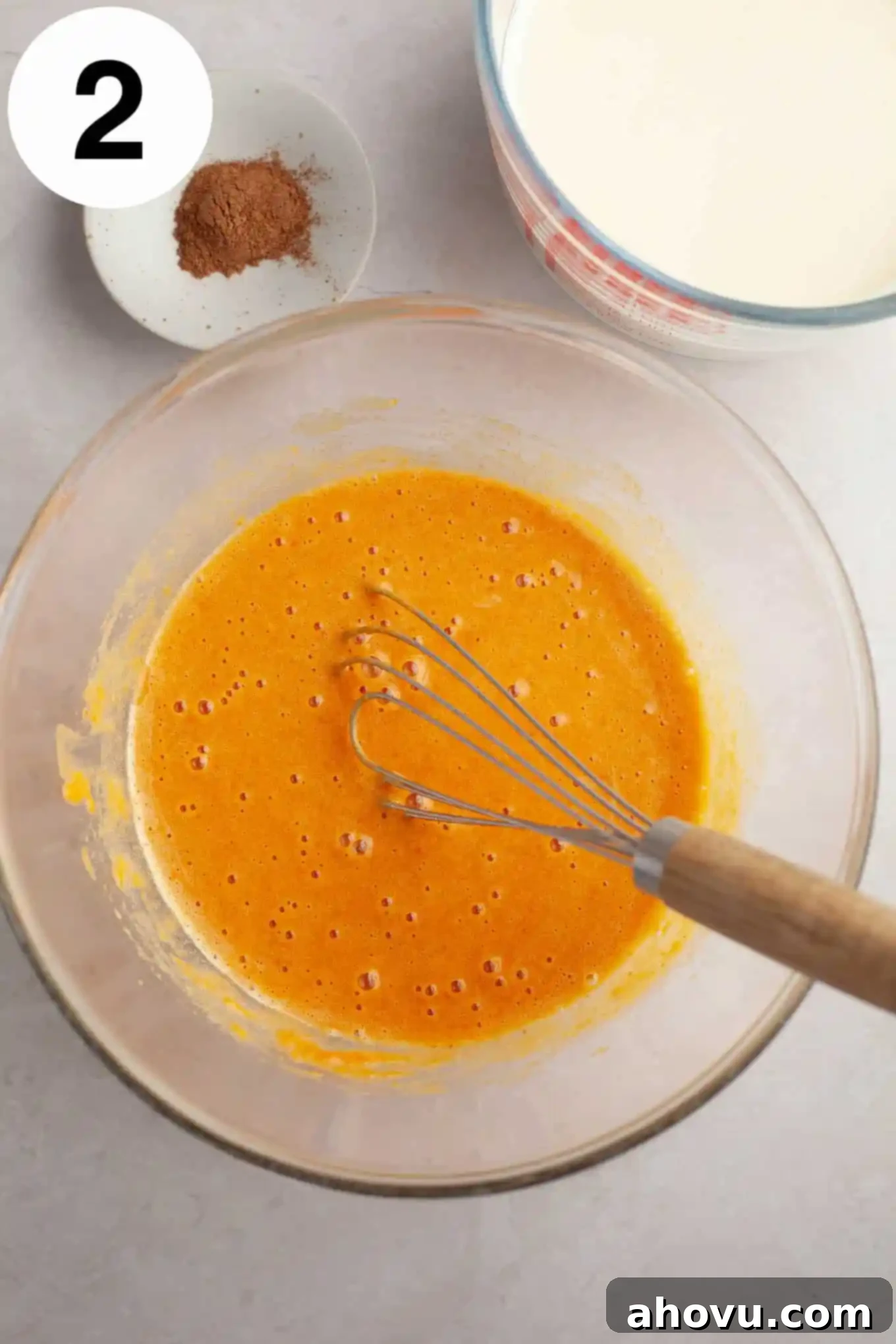 An overhead view of a smooth pumpkin and egg yolk mixture, incorporating vanilla extract.